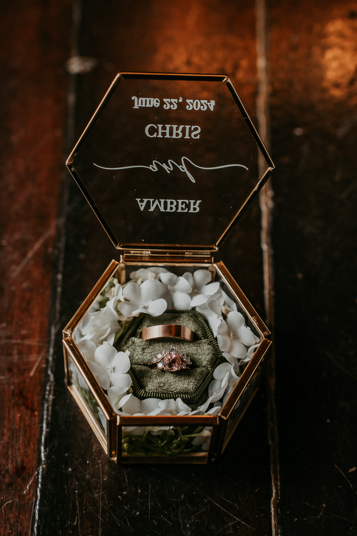 Close-up of a ring box holding the wedding rings, placed on a rustic table at Hacienda Siesta Alegre.