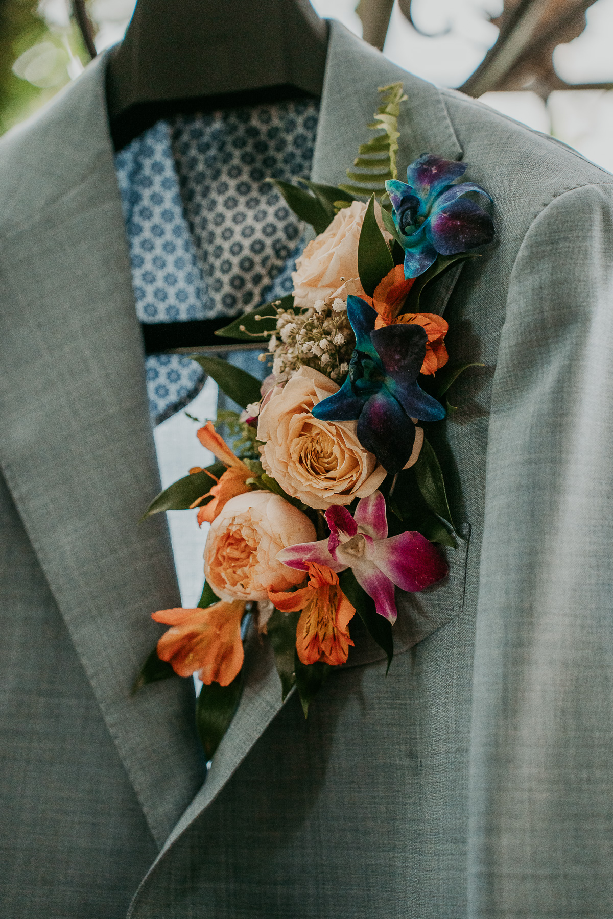 Groom's tailored suit adorned with a boutonniere of fresh flowers, showcasing a touch of elegance and personal style.