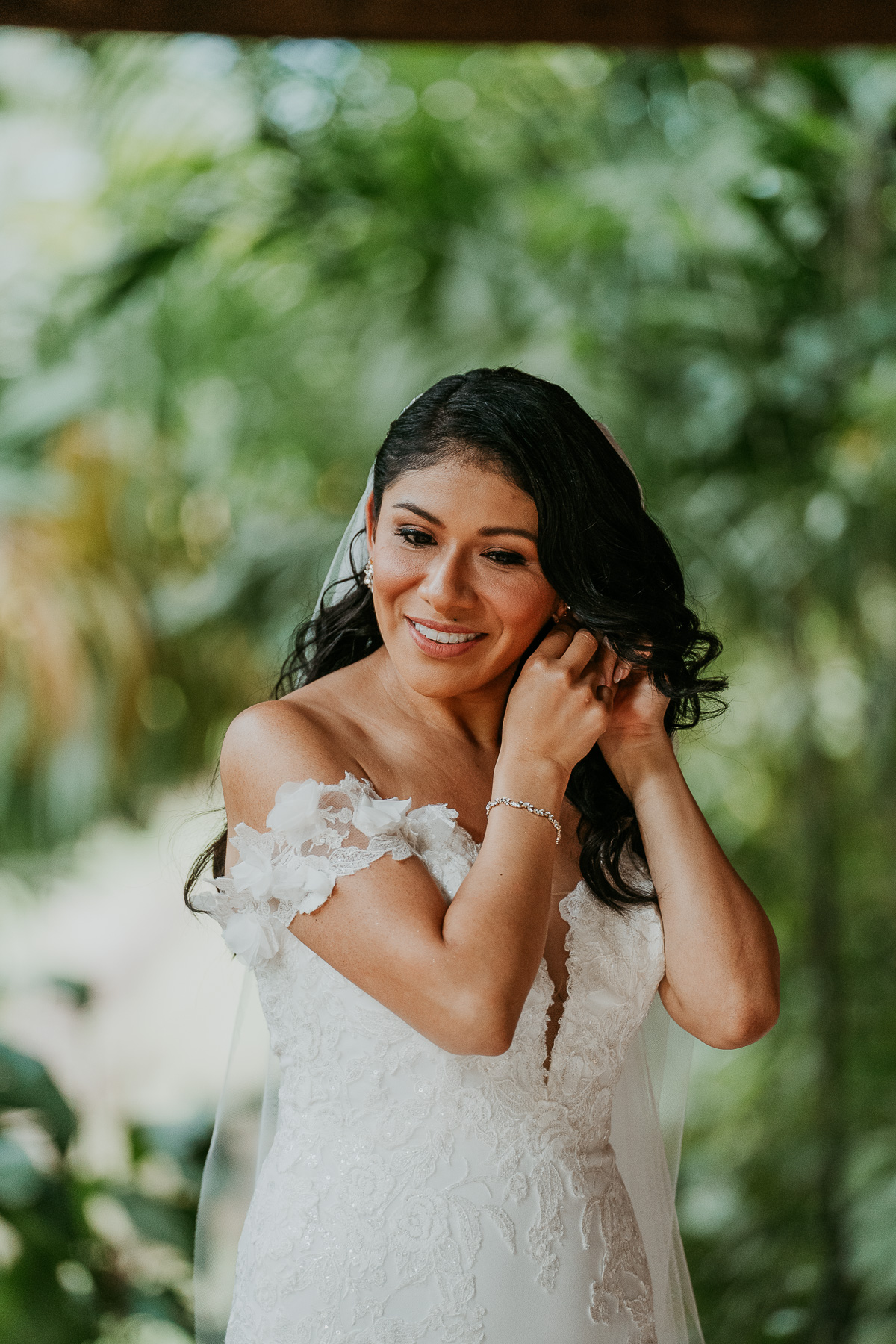 Bride preparing for her big day outside the Flamboyan room at Hacienda Siesta Alegre, with lush foliage and natural light surrounding her.