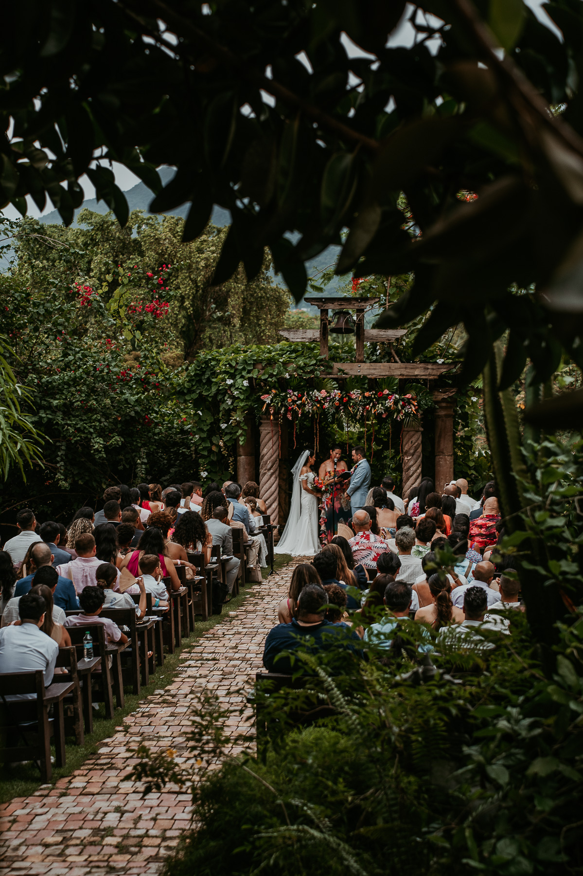 Romantic twilight wedding ceremony at Hacienda Siesta Alegre with guests seated under twinkling lights and lush greenery.