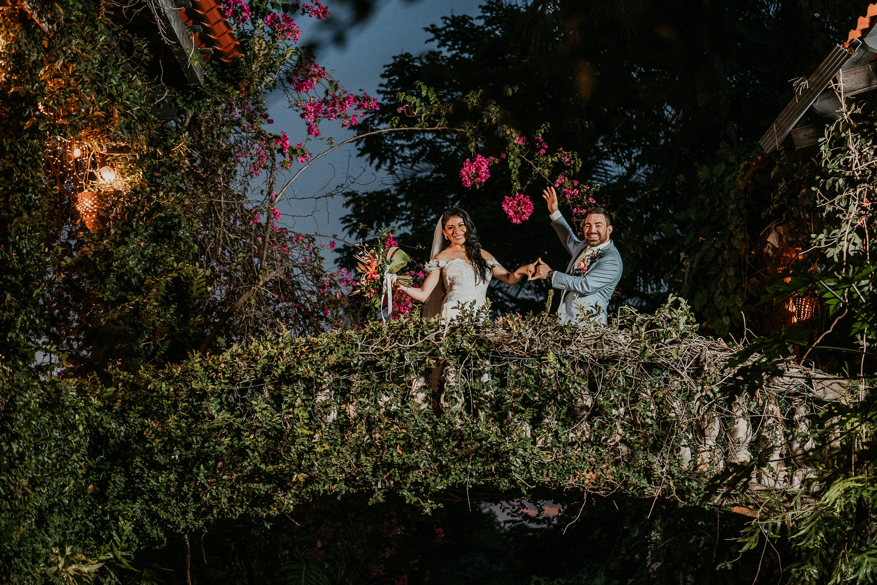 Bride and groom posing at night on top of the famous Hacienda Siesta Alegre bridge.