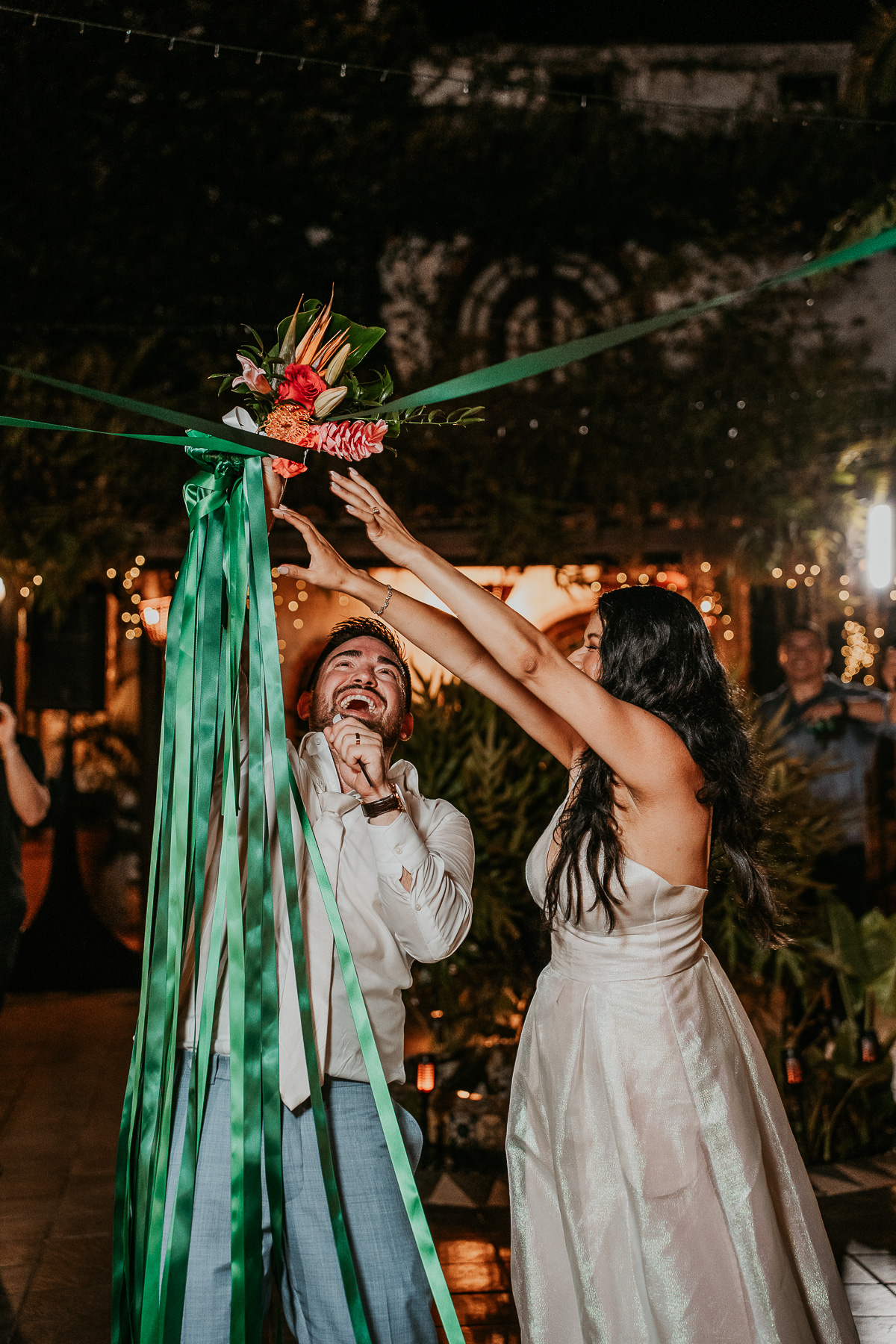 Guests gathered around with excitement as the bride prepares to cut the ribbon during the unique wedding celebration.