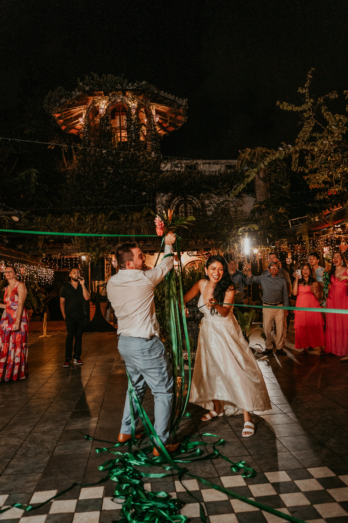 Guests gathered around with excitement as the bride prepares to cut the ribbon during the unique wedding celebration