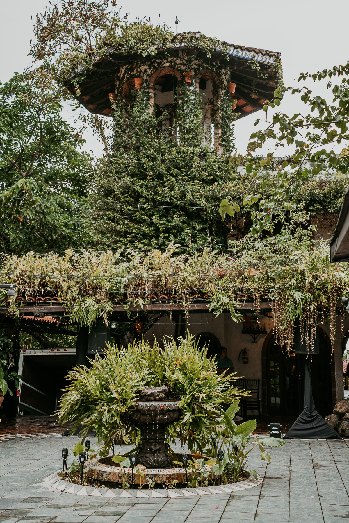 Hacienda Siesta Alegre's enchanting open-air venue with rustic arches, lush tropical foliage, and a view of the surrounding mountains.