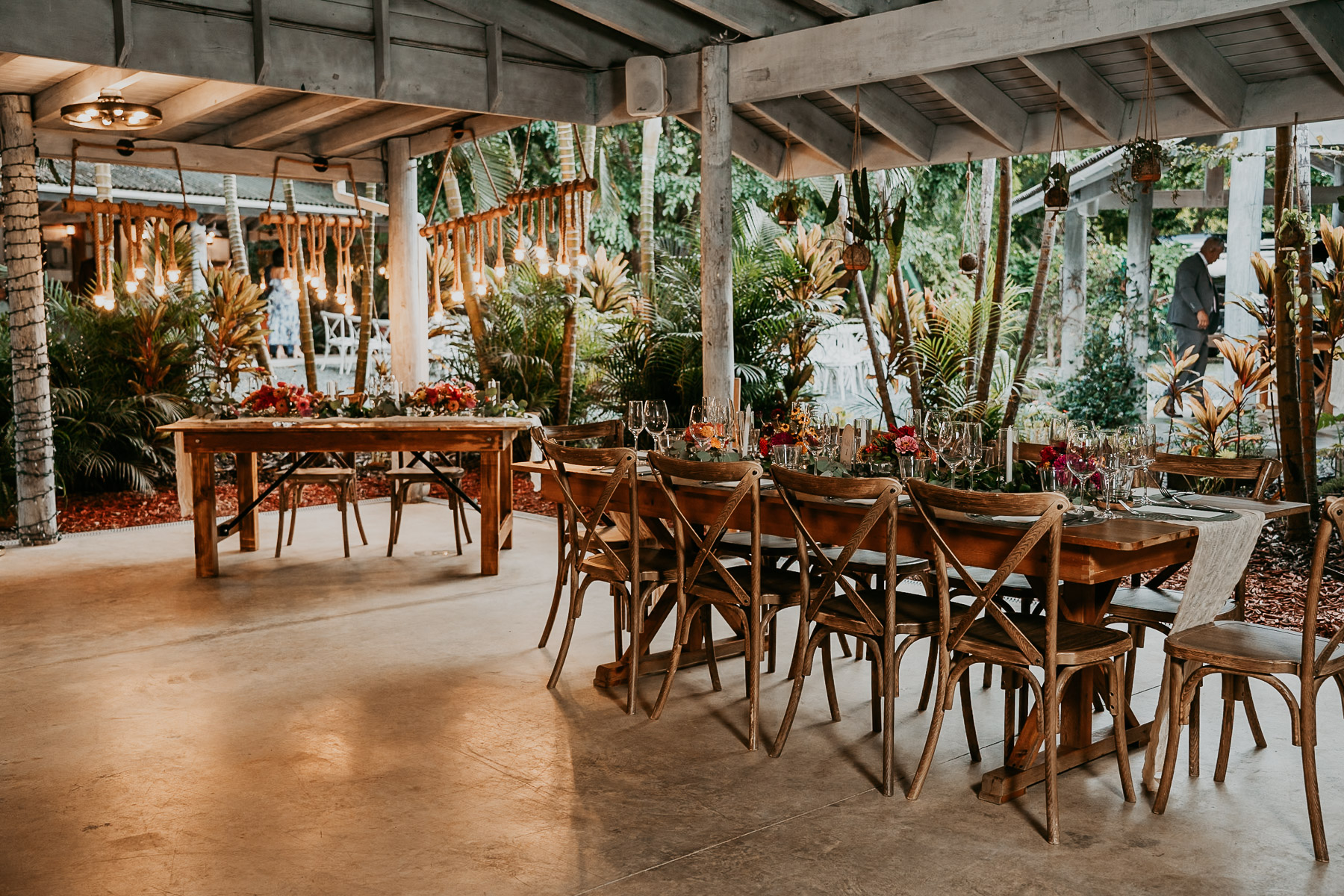 Rustic rattan decor and fresh tropical floral arrangements on tables at La Bromelia hall in Aldeana Cidra.