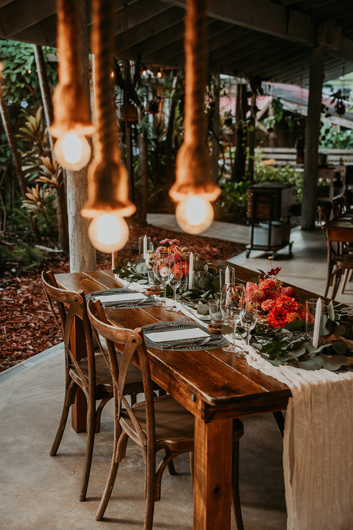 Rustic rattan decor and fresh tropical floral arrangements on tables at La Bromelia hall in Aldeana Cidra.