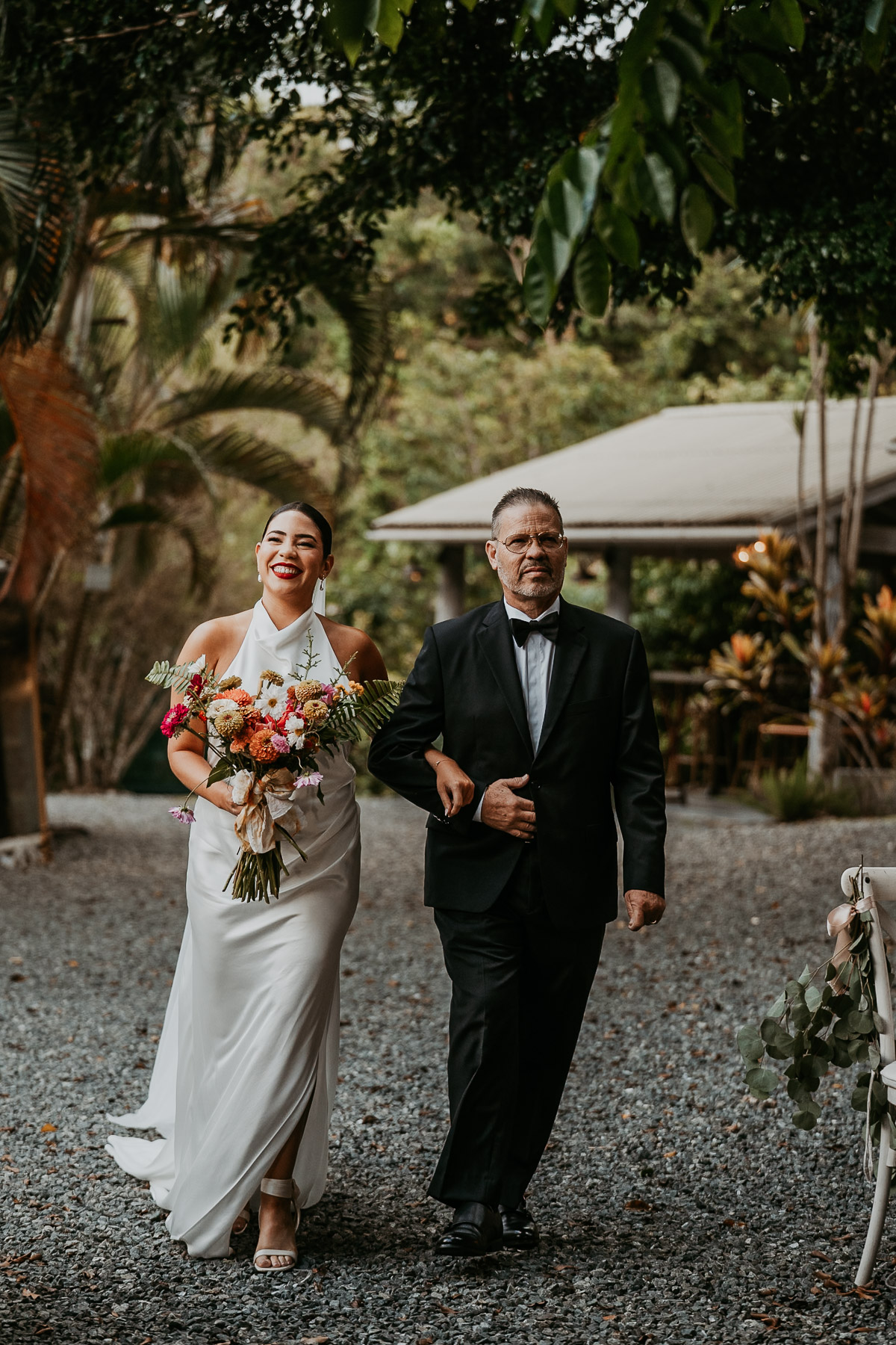 Bride walking down the isle with father in hand during mountain wedding ceremony.