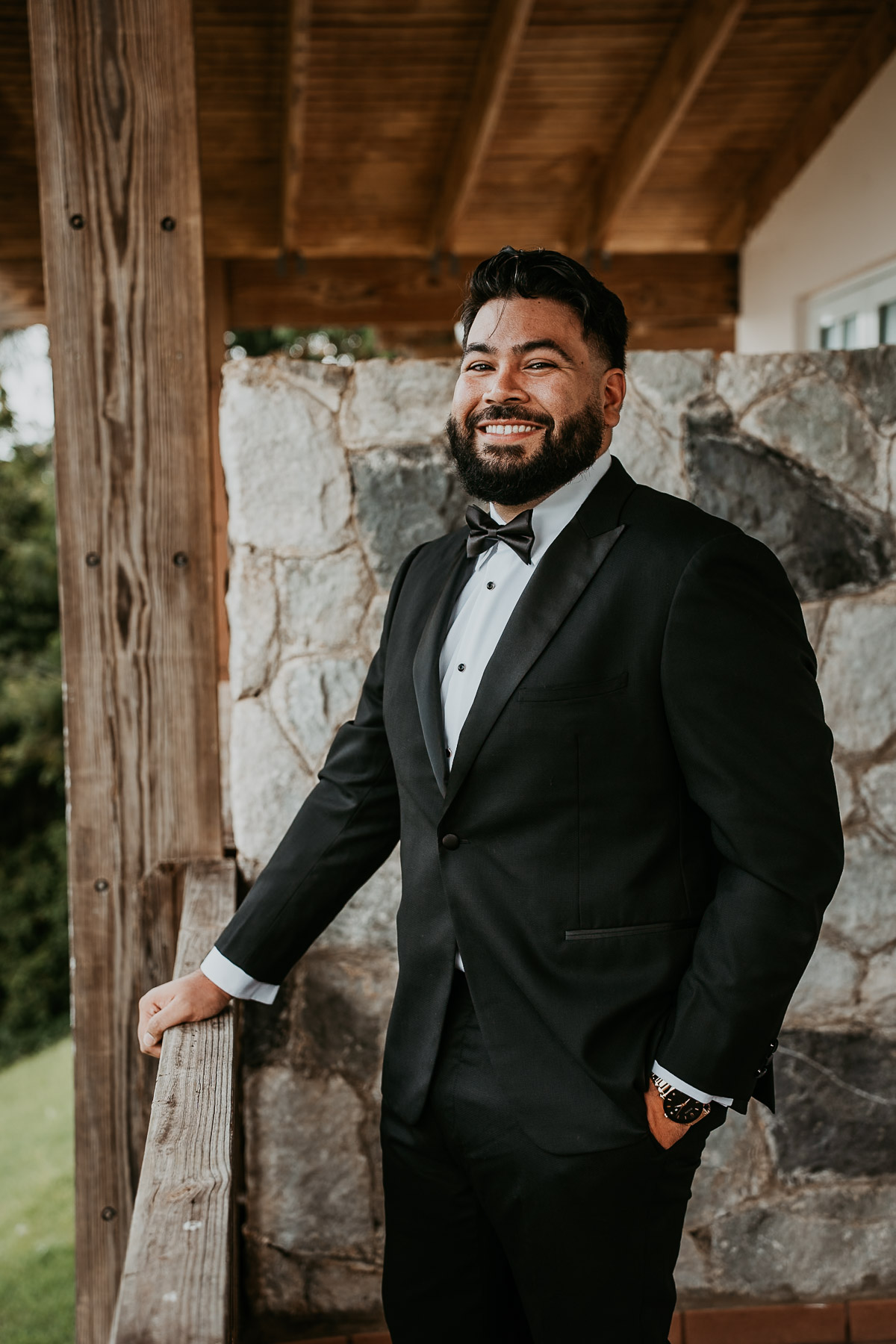A cheery portrait of a groom standing on room balcony at Aldeana venue.