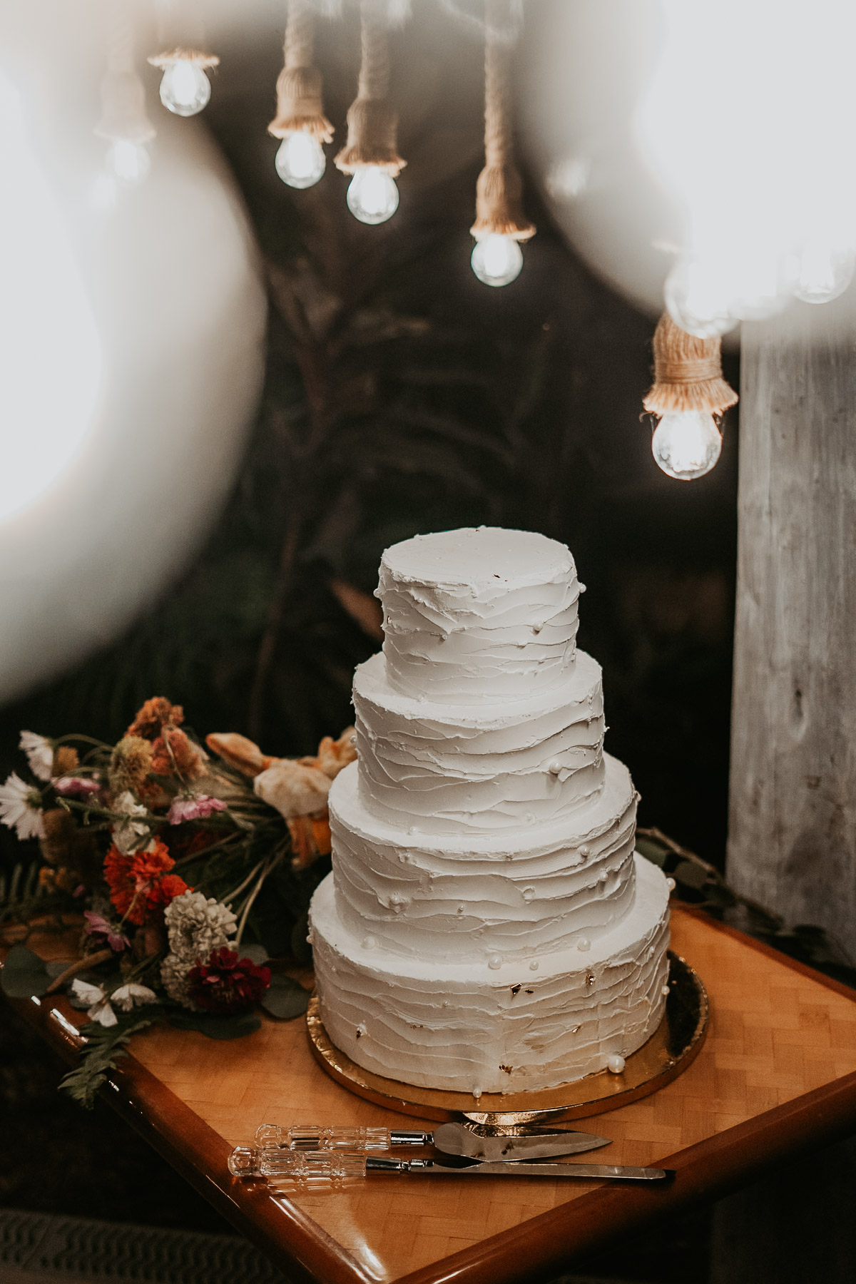 Close up of a modern wedding cake decorated with native tropical leaves at a Cidra wedding space.