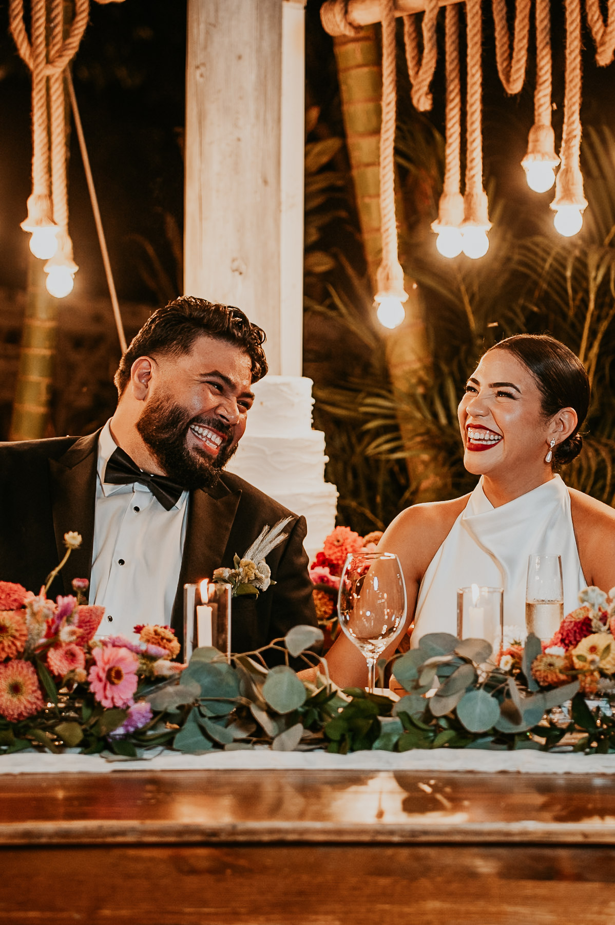 A newlywed couple sitting at their sweetheart table.