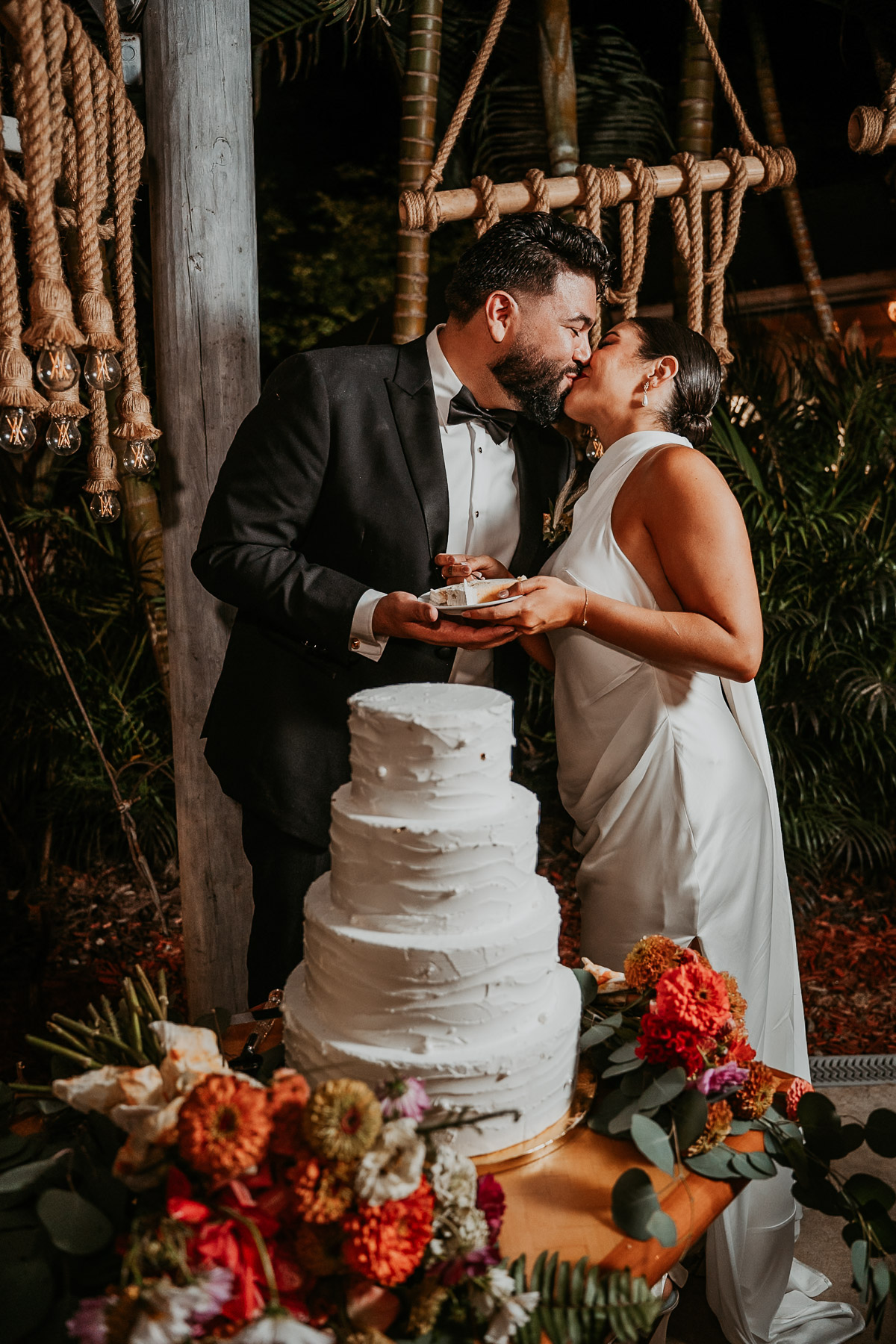Candid photo of a newlywed couple laughing and feeding each other cake during their reception at Aldeana, one of the premier wedding venues in puerto rico.