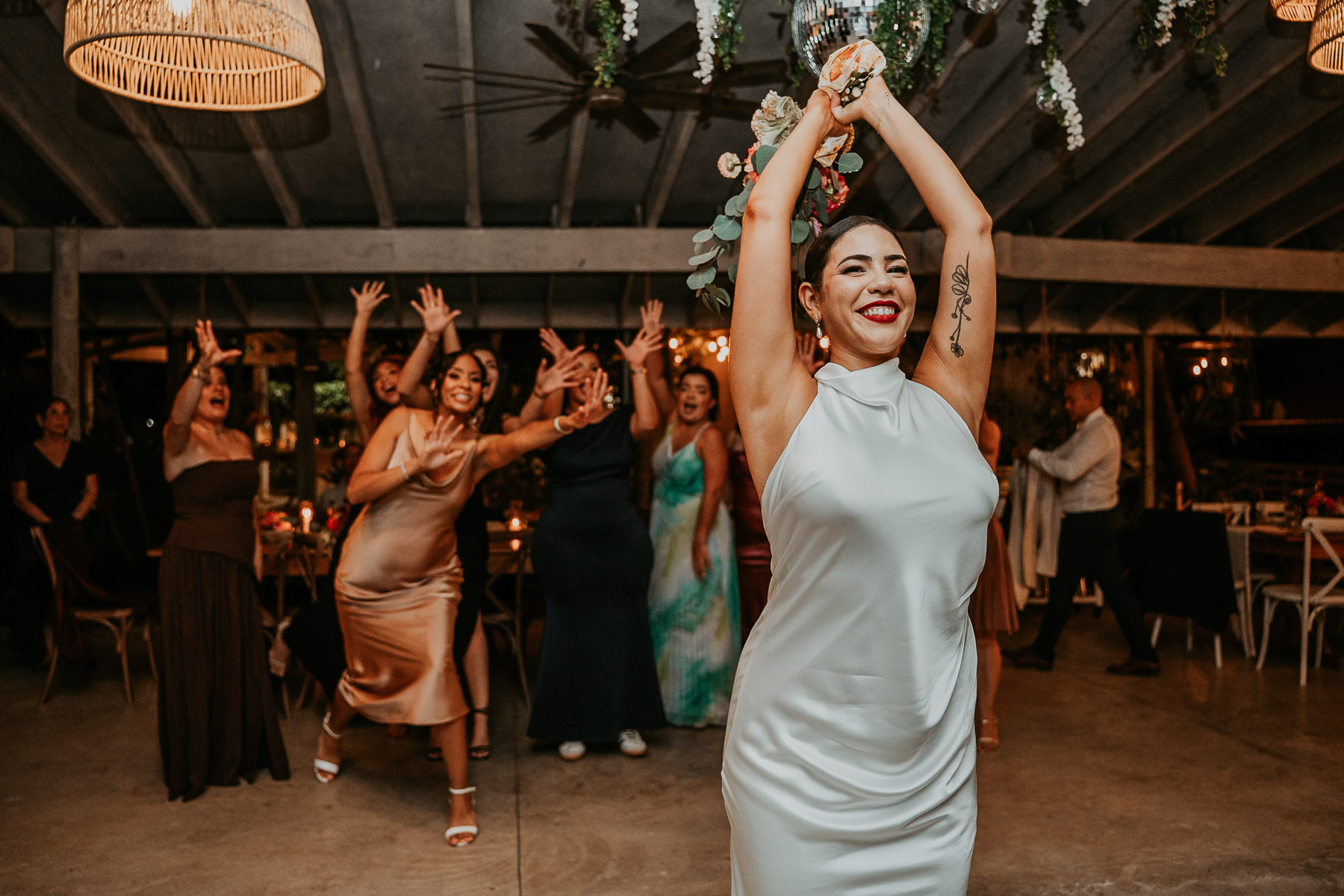 A fun, movement-filled snapshot of the bouquet toss during an intimate wedding reception in Puerto Rico.