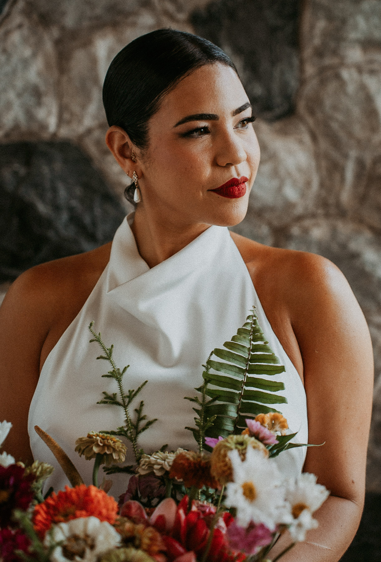 An elegant portrait of a bride against rustic rock wall surrounded by the soft, diffused mountain light of the Puerto Rican cordillera.