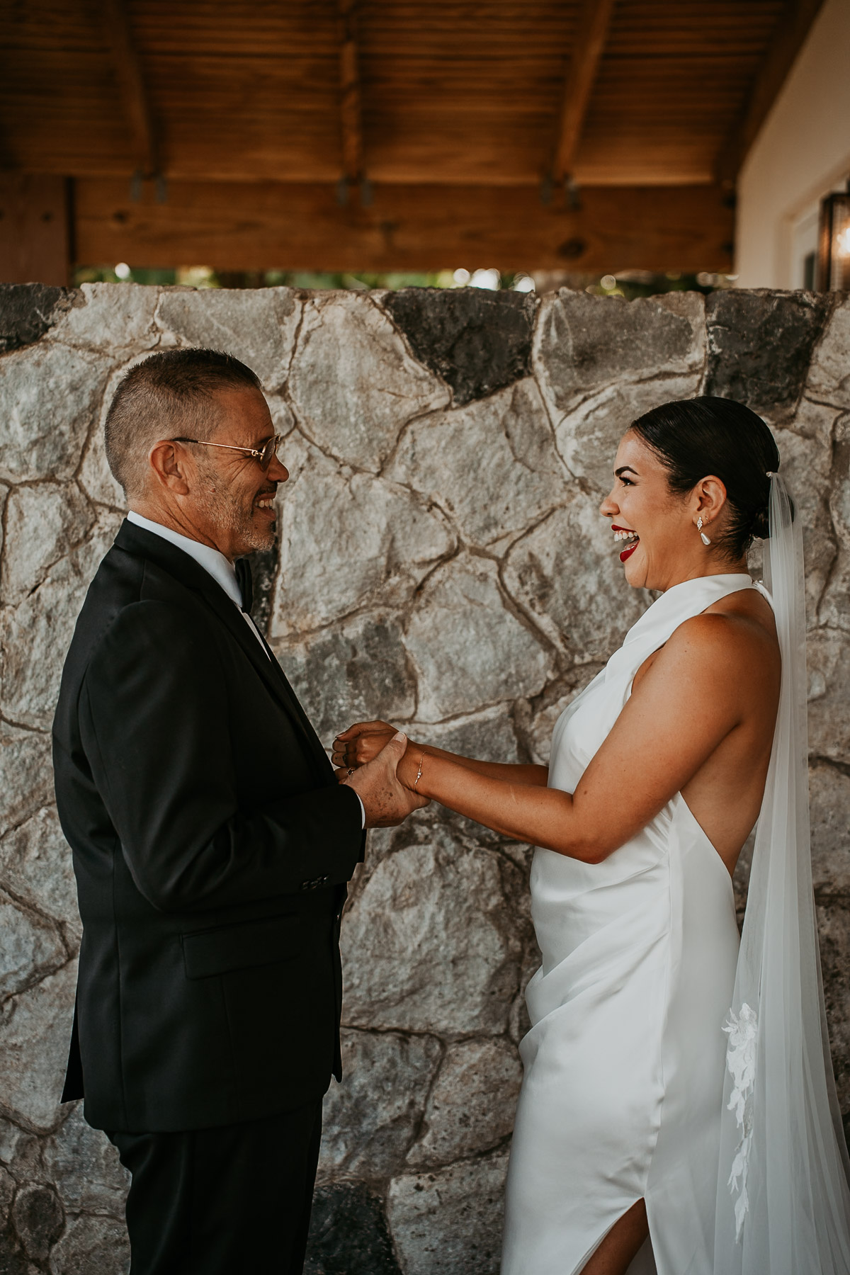 A true, unscripted expression of joy between a bride and her father during a private moment.