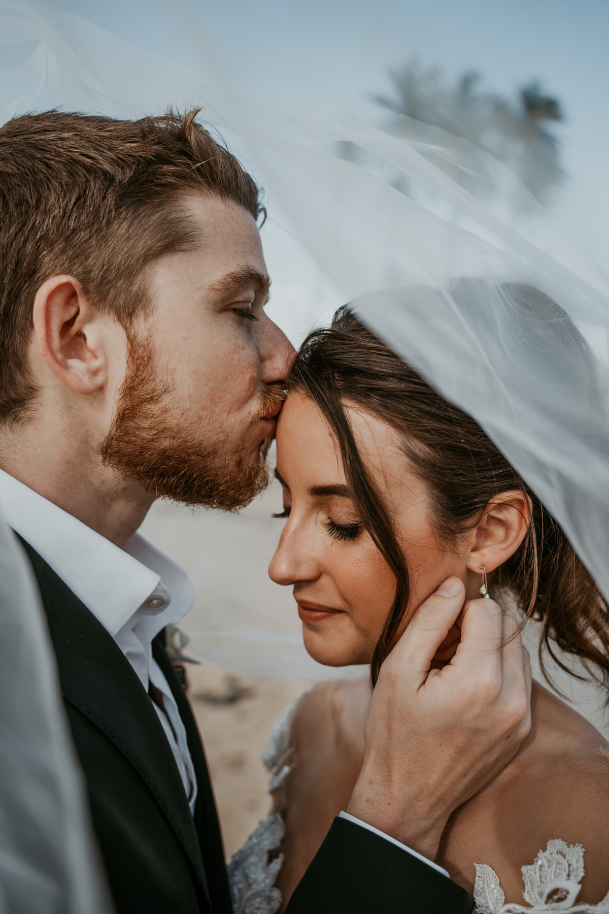 A couple under a veil at a beach in Puerto Rico during their wedding at the Hyatt.