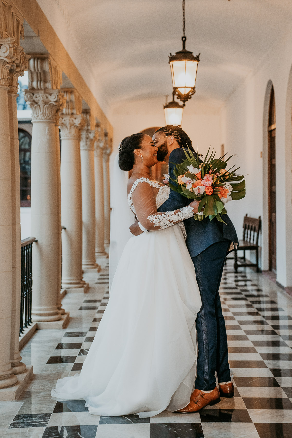 Bride and Groom Embrace at Casa de España’s Historic Corridors