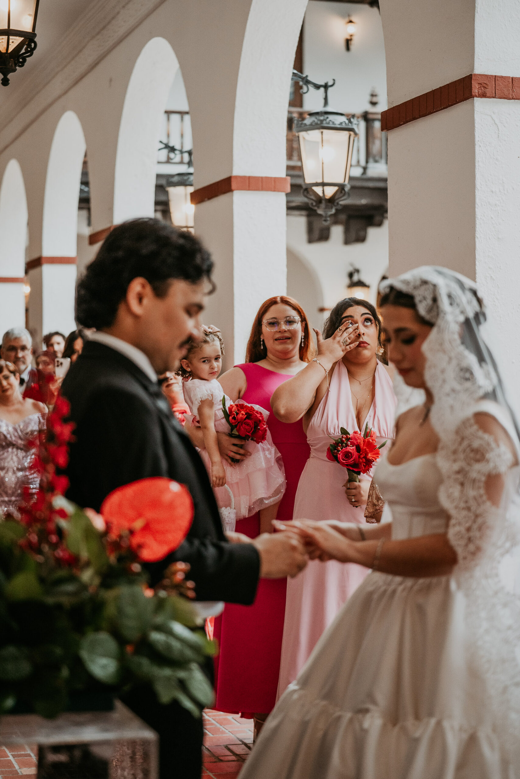Intimate wedding moment in historic Casa de España during rainy day.