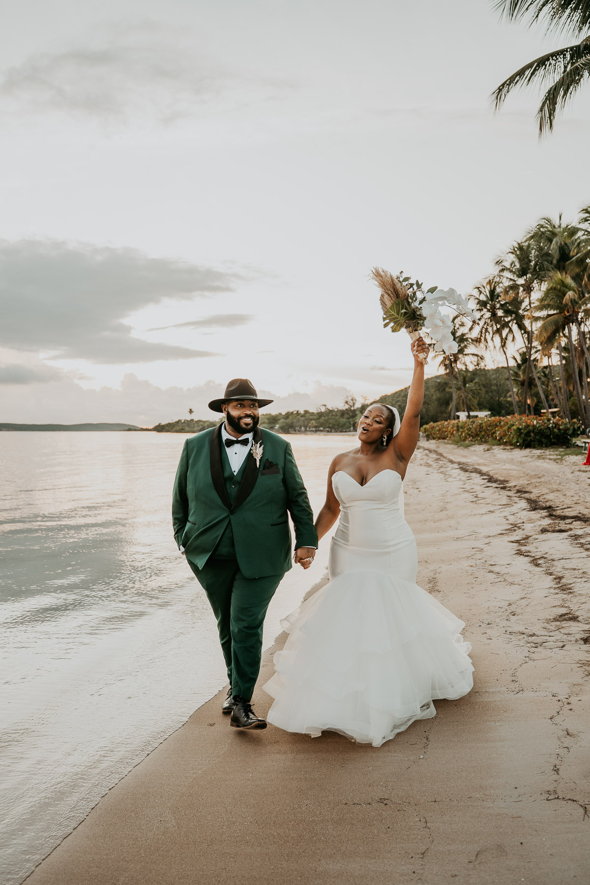 Newlyweds walking along the beach after their Copamarina Beach Resort wedding.