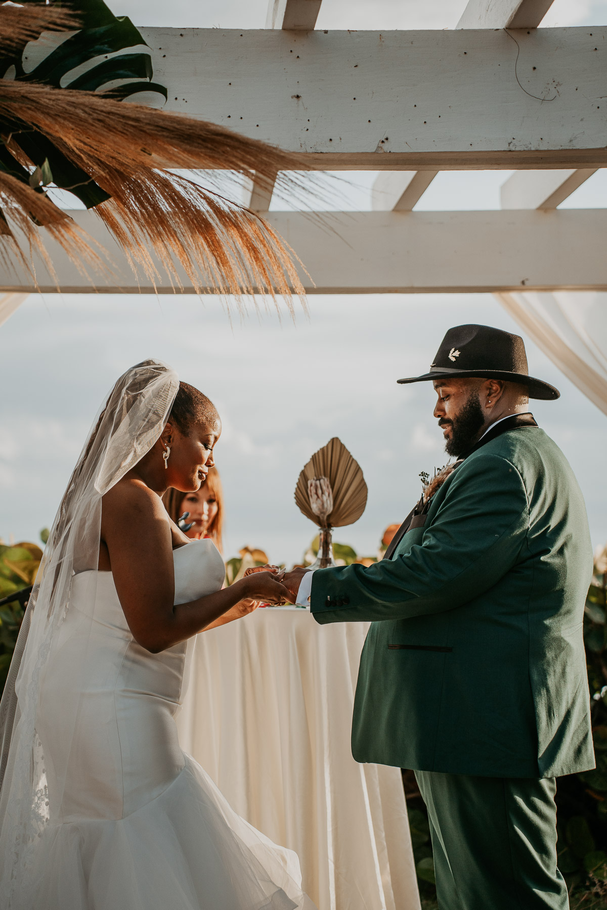 Couple exchanging wedding rings during their outdoor wedding ceremony.
