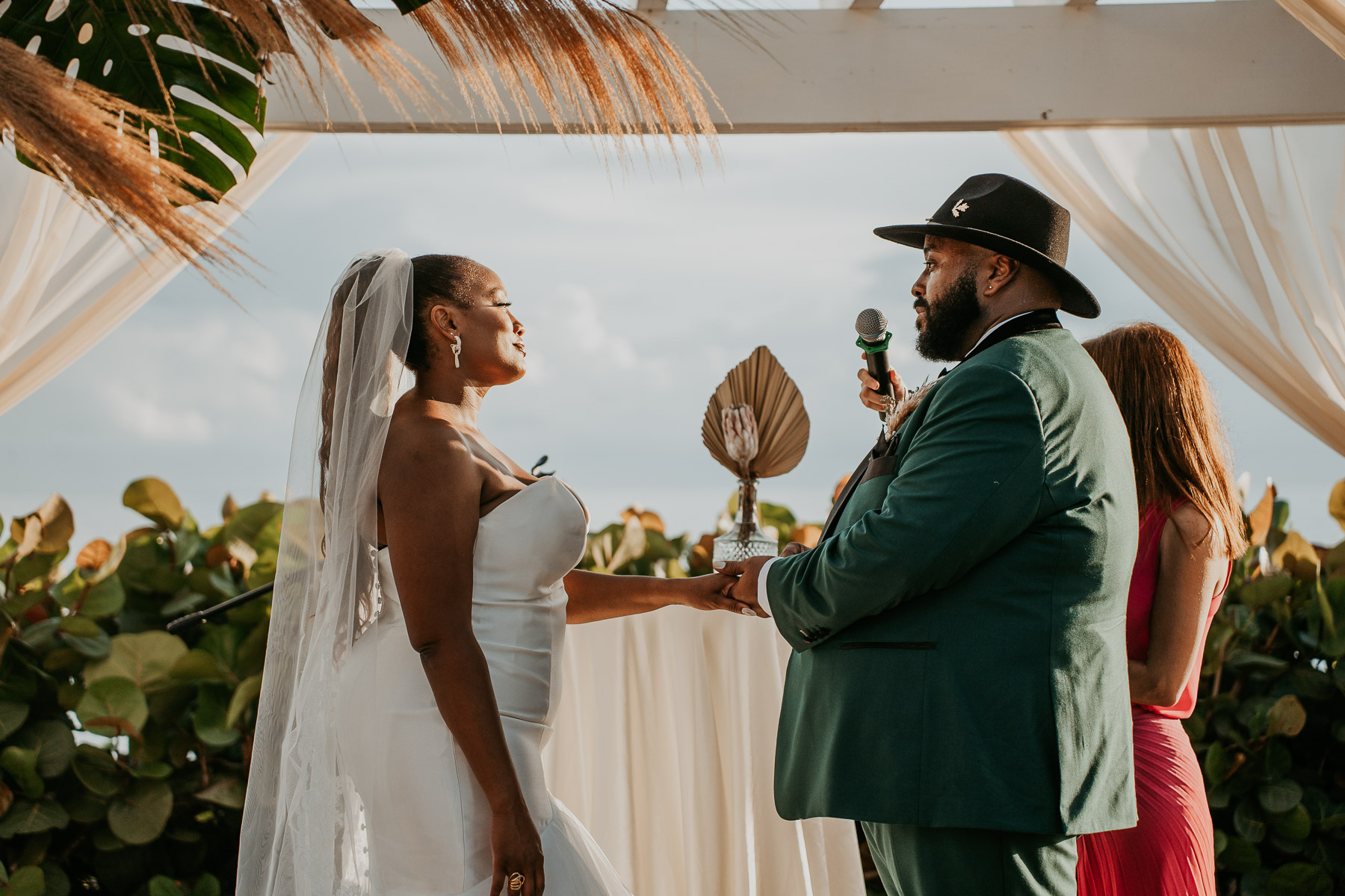 Couple exchanging wedding rings during their outdoor wedding ceremony.