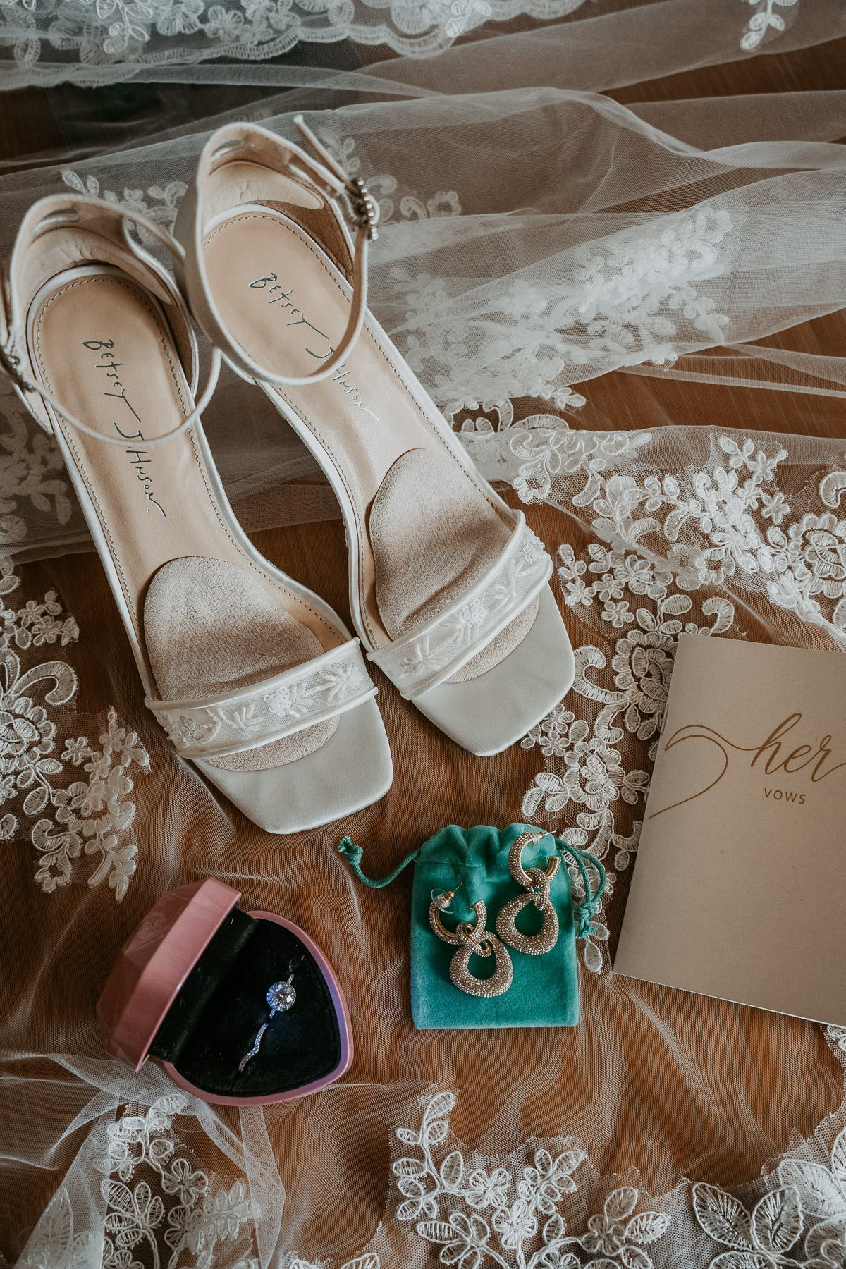 Bride's wedding details featuring a pink ring box and engagement ring.