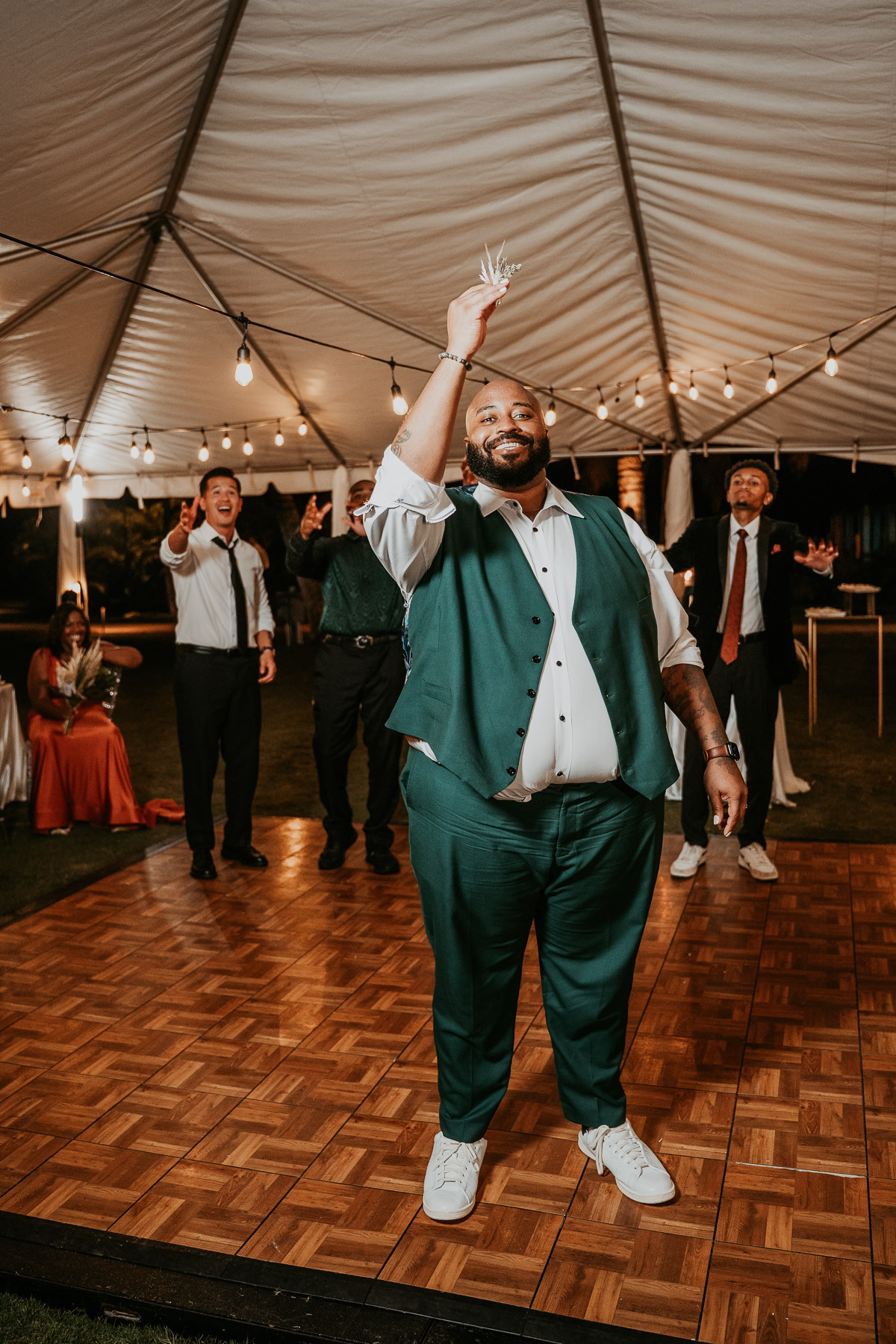 Groom playfully tossing his boutonniere during the wedding celebration.