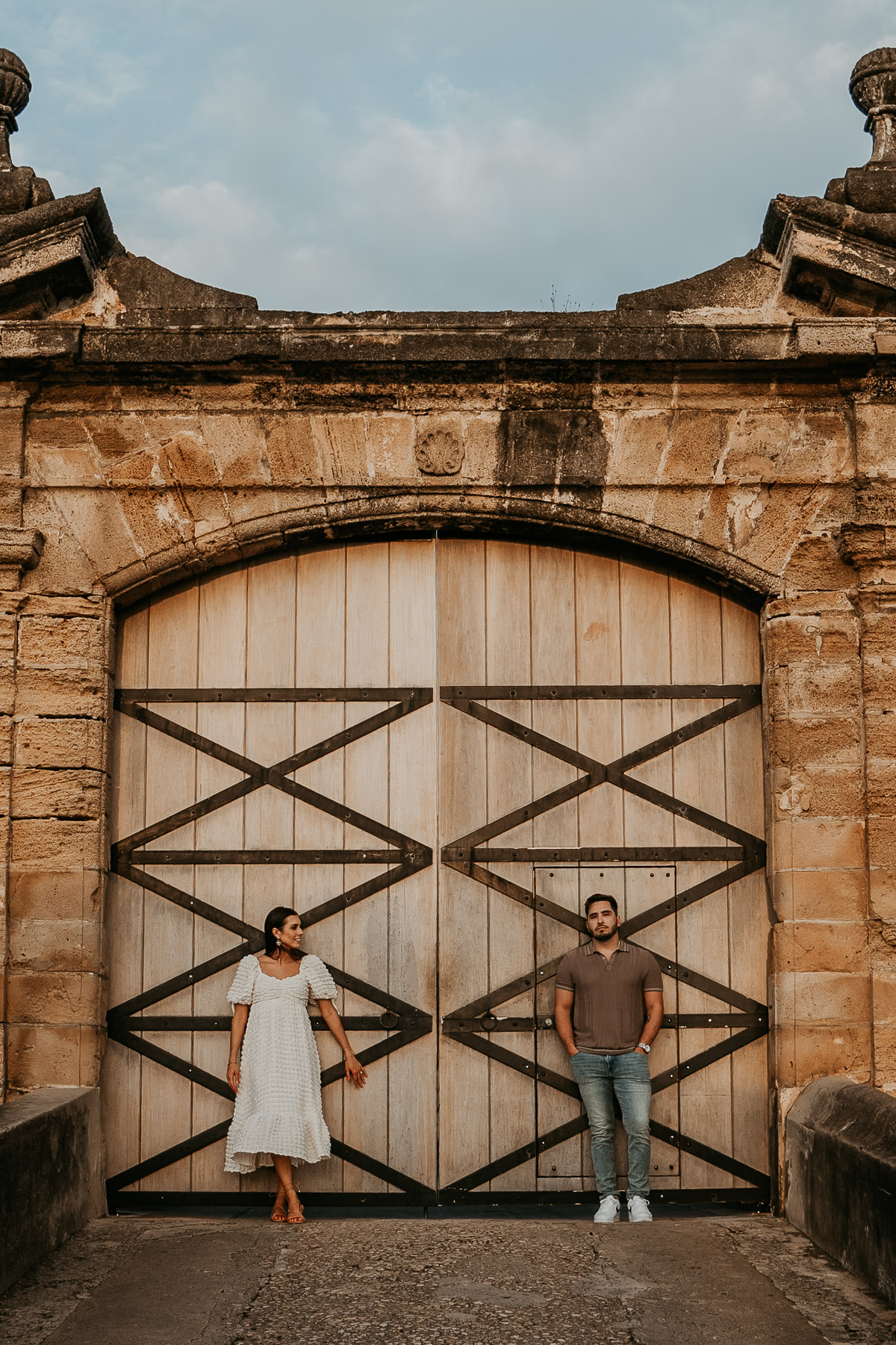 Couple standing in front of the the door of the San Cristobal fort.