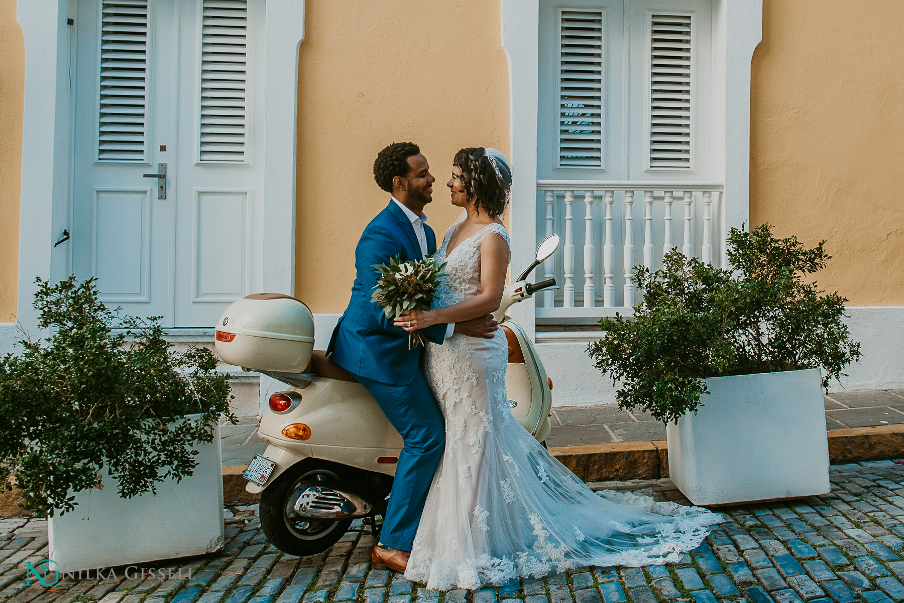 A couple at Old San Juan sitting on a moped after their ceremony captured by a photoghrapher.