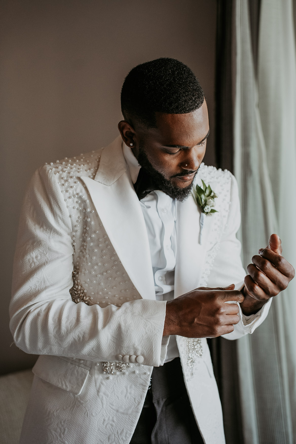 Groom getting ready with natural light in El Conquistador Resort suite