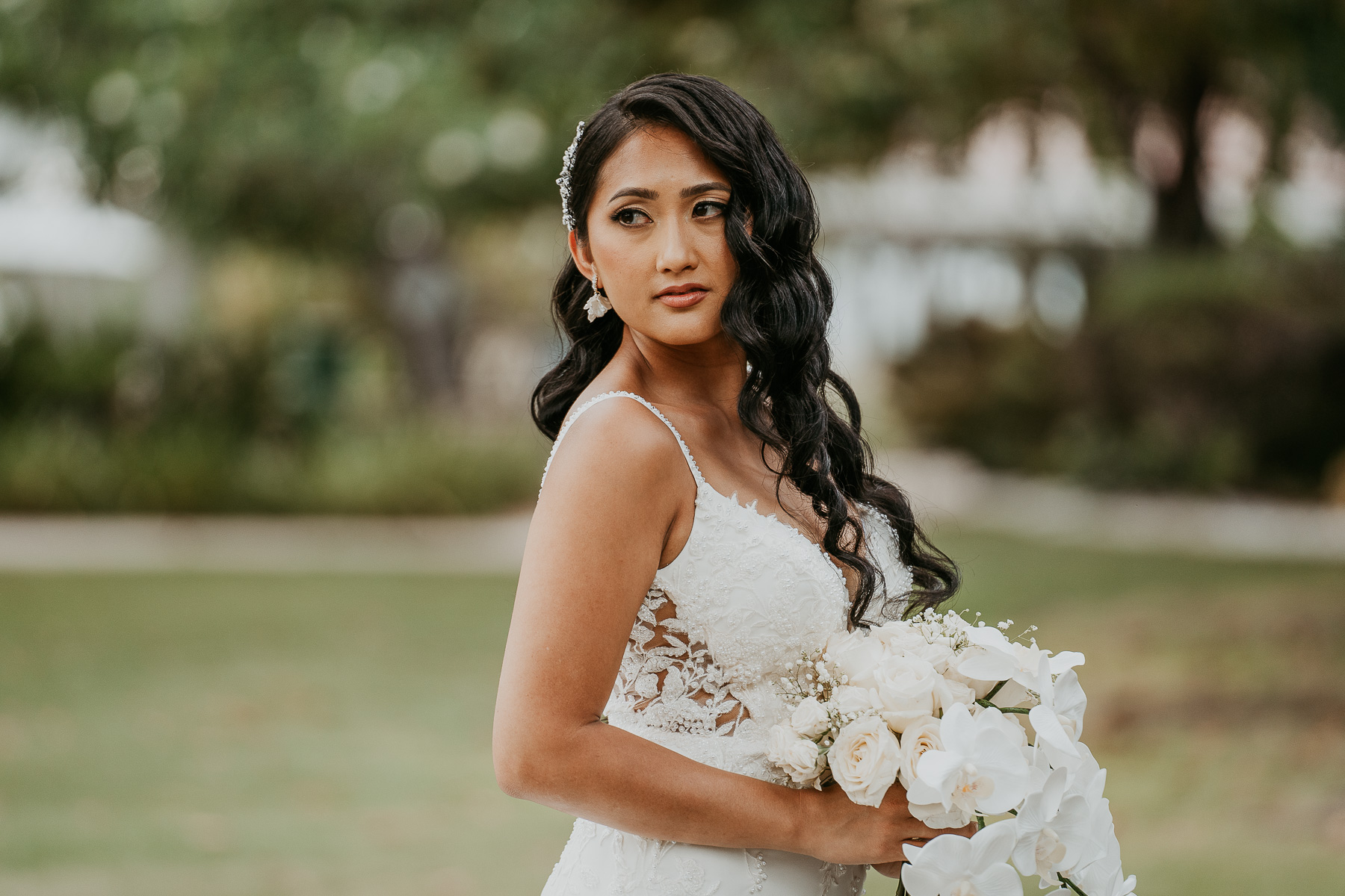 Bride posing gracefully by the gardens at Copamarina Beach Resort, with a serene garden backdrop.