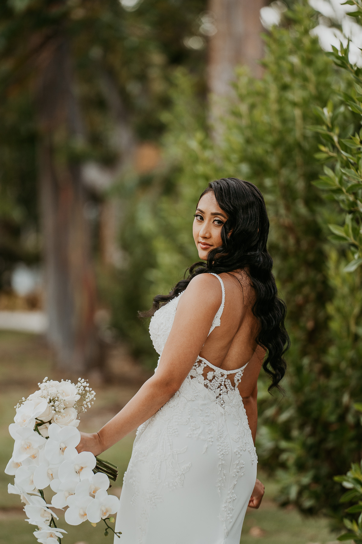 Bride posing gracefully by the gardens at Copamarina Beach Resort, with a serene garden backdrop.