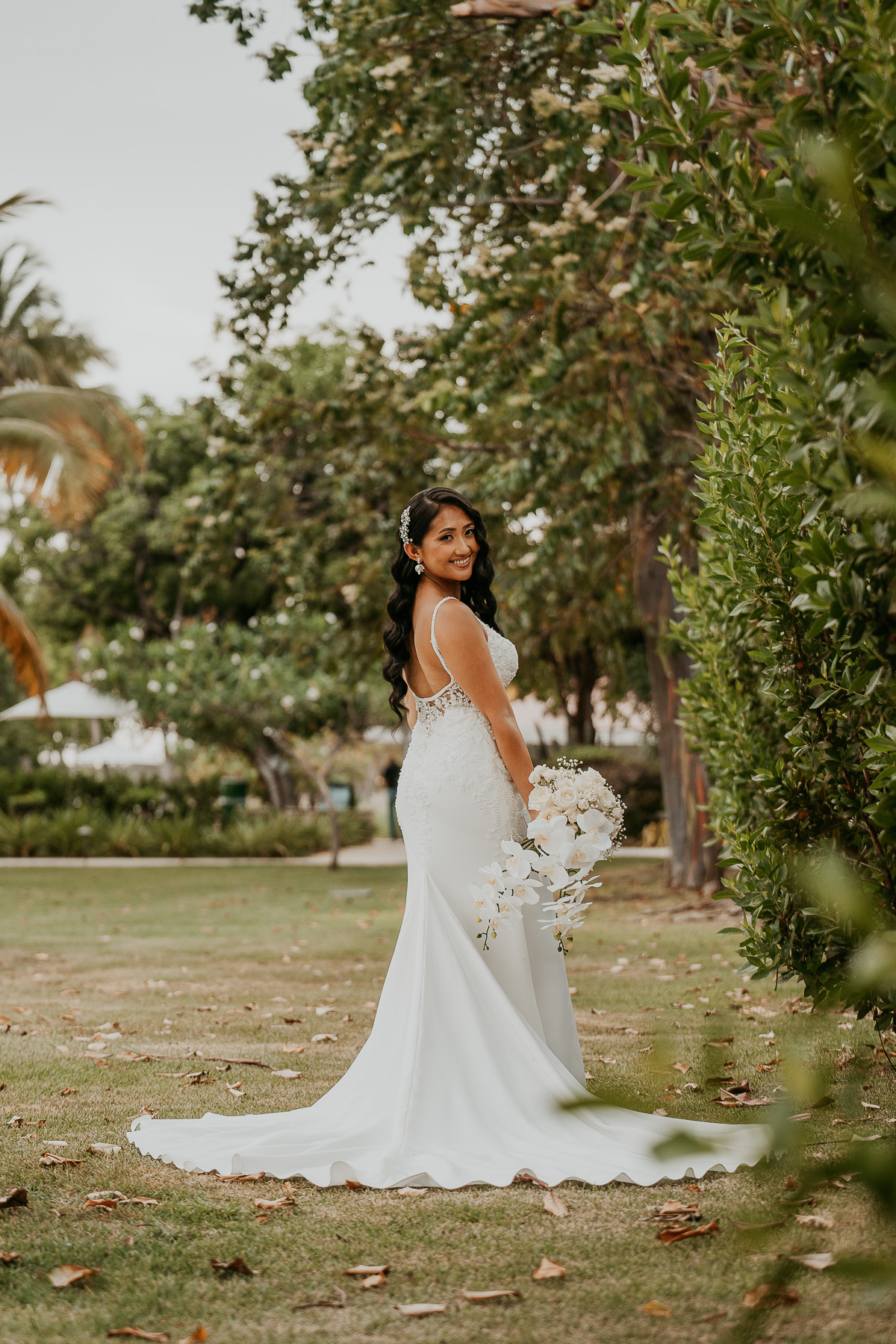 Bride posing gracefully by the gardens at Copamarina Beach Resort, with a serene garden backdrop.