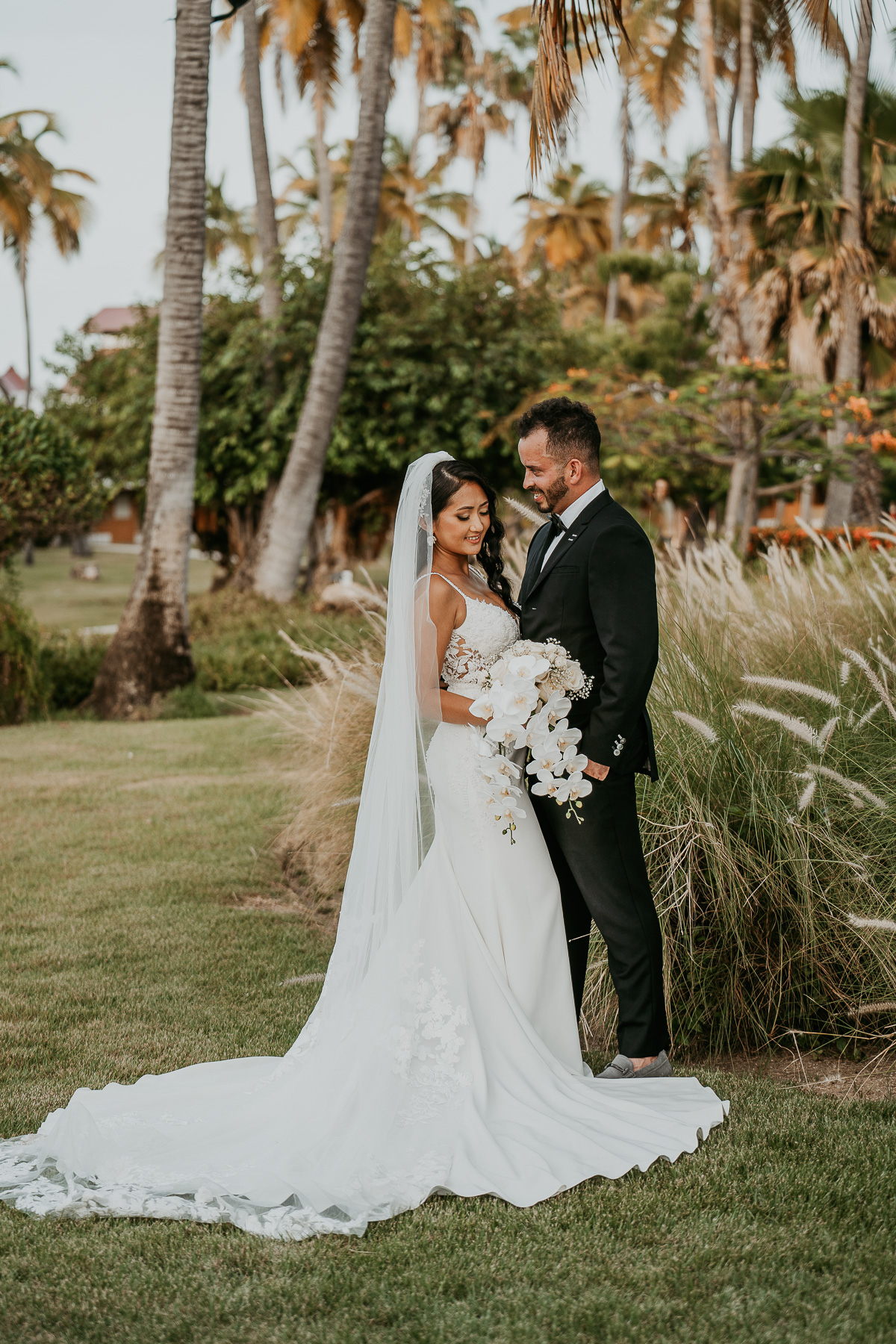 Newlyweds sharing a romantic moment under the palm trees at Copamarina Beach Resort