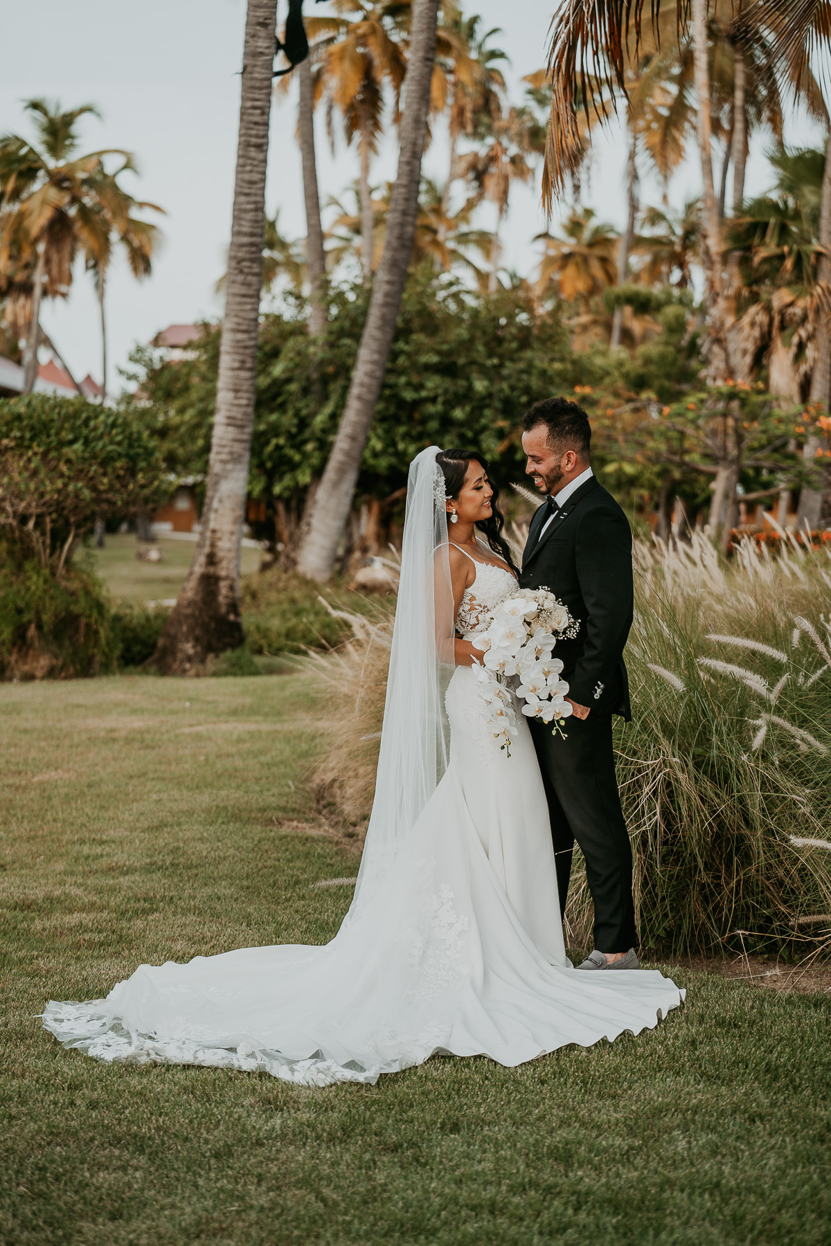 Newlyweds sharing a romantic moment under the palm trees at Copamarina Beach Resort