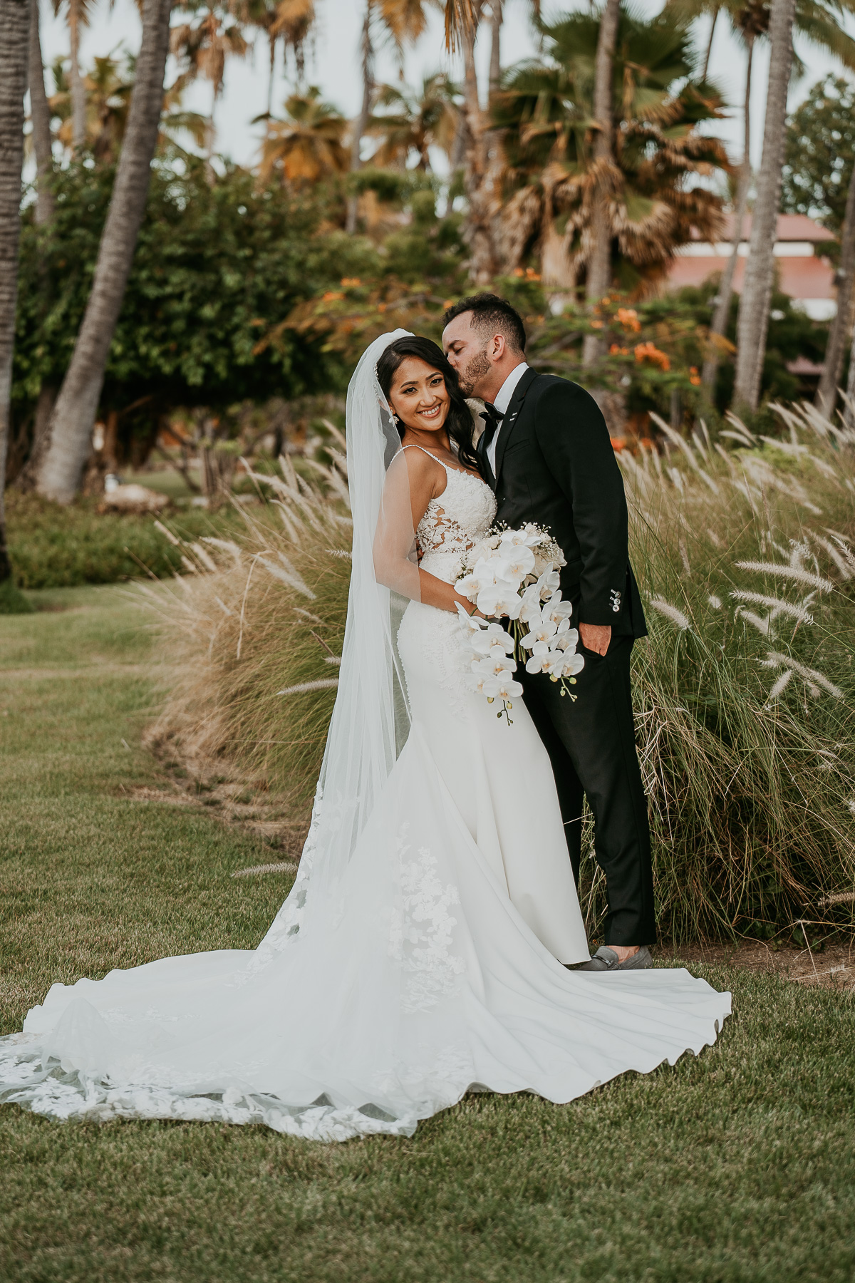 Newlyweds sharing a romantic moment under the palm trees at Copamarina Beach Resort.