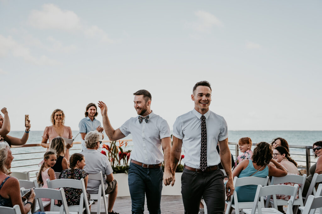 Gay couple celebrating their micro wedding at at beachfront venue.