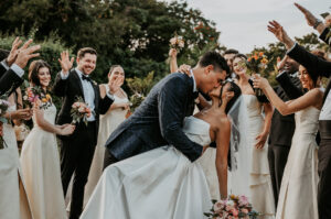 Bride and groom kiss at Hacienda Campo Rico surrounded by friends.