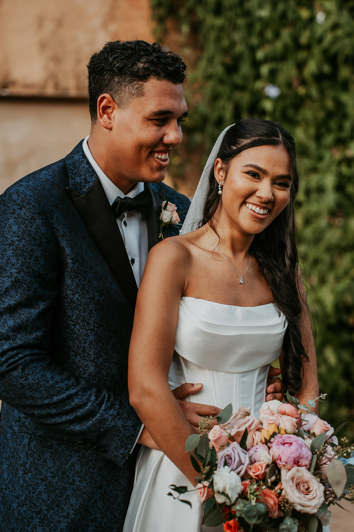 Couple embracing against rustic Spanish style walls at Puerto Rico hacienda venue.