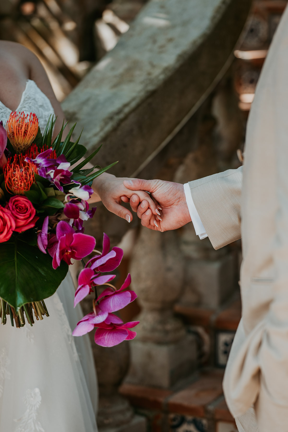 Close-up of newlyweds holding hands and embracing