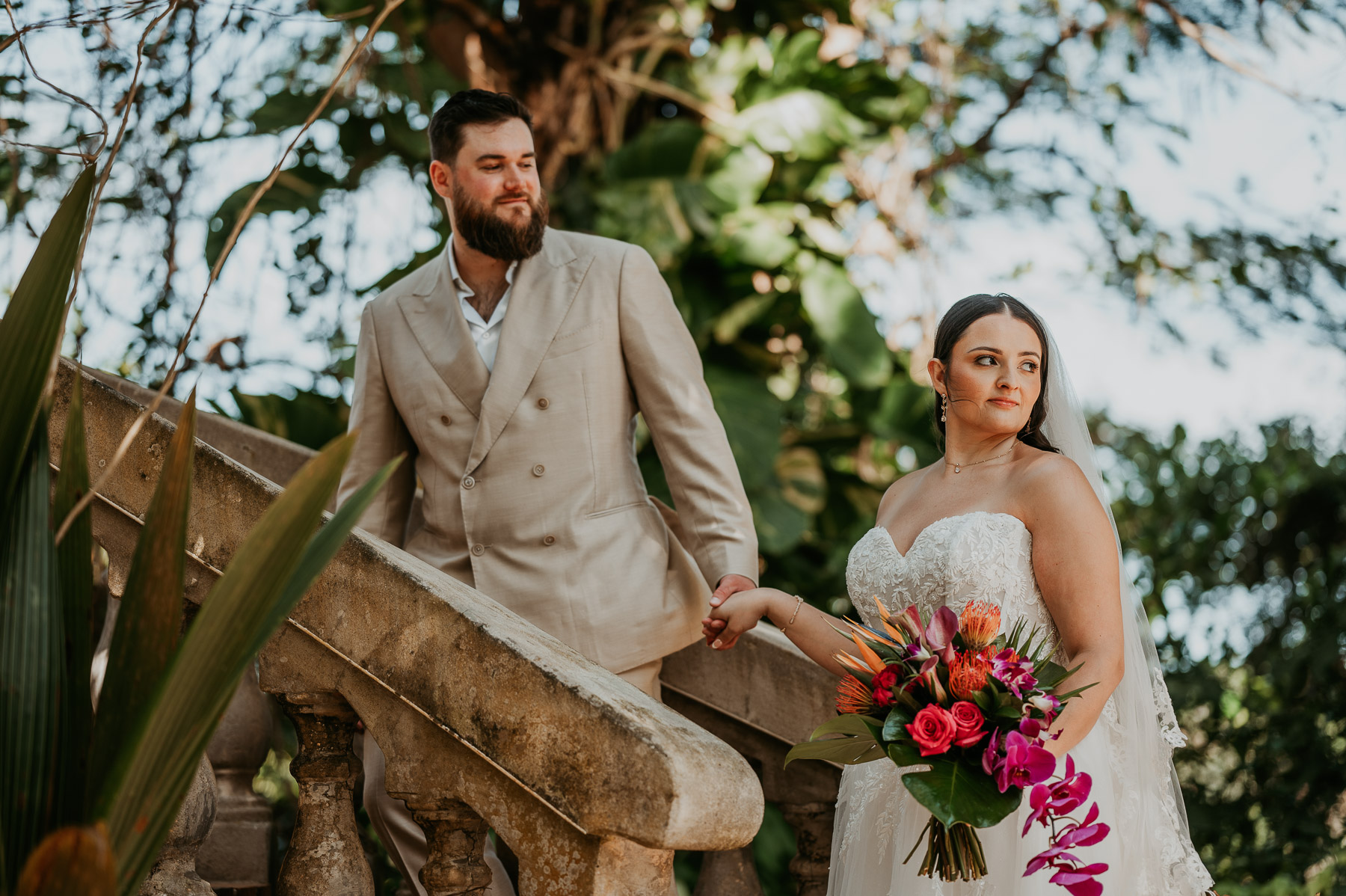 Couple posing together beside the lush gardens near stairs at Hacienda Siesta Alegre