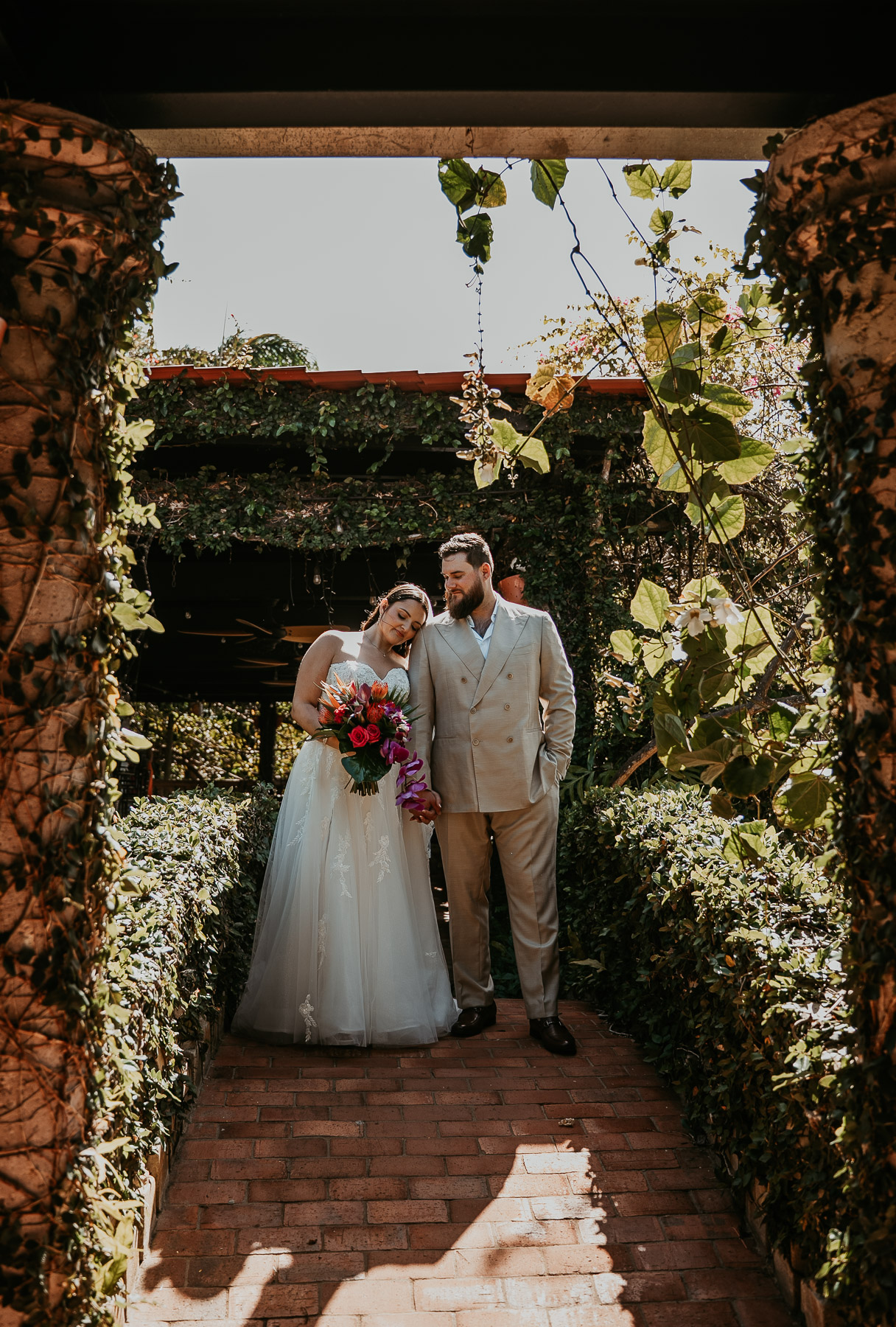 Couple posing together beside the lush gardens at Hacienda Siesta Alegre