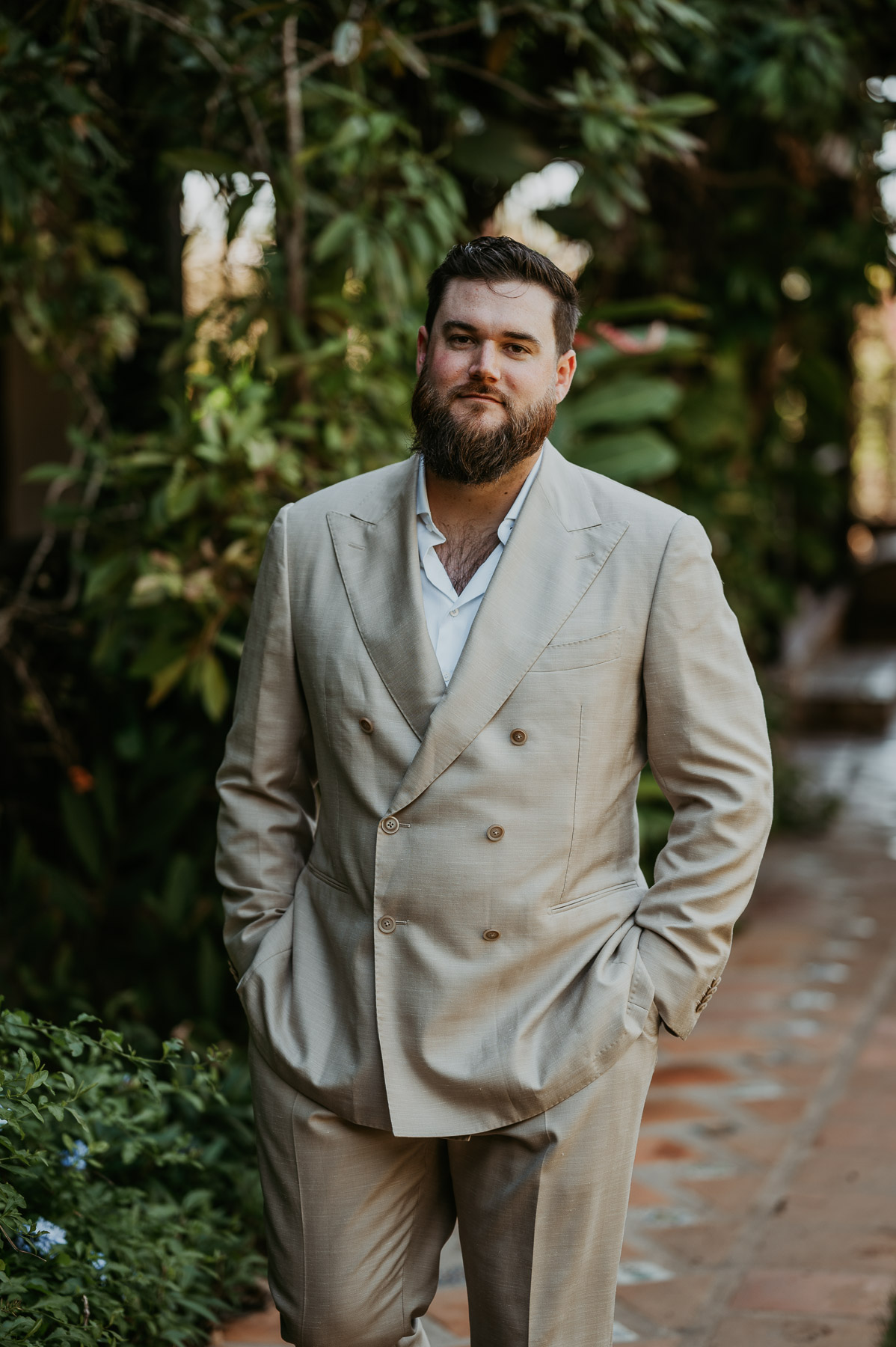 Groom showing off wedding suit during portraits