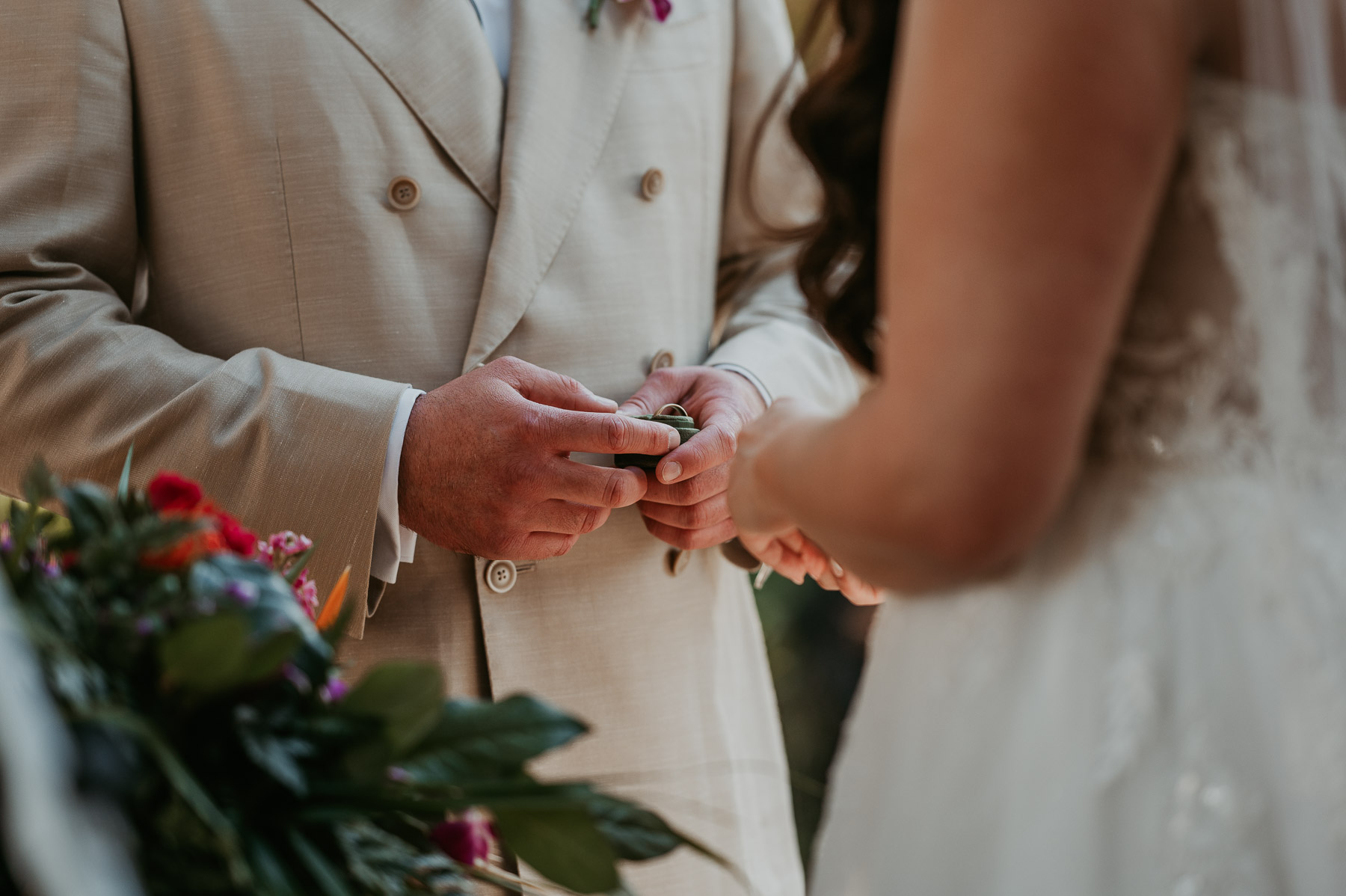 Couple exchanging wedding rings during their outdoor ceremony