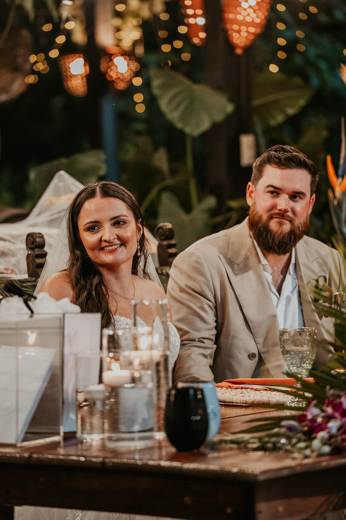 Newlywed couple smiling during the reception toast