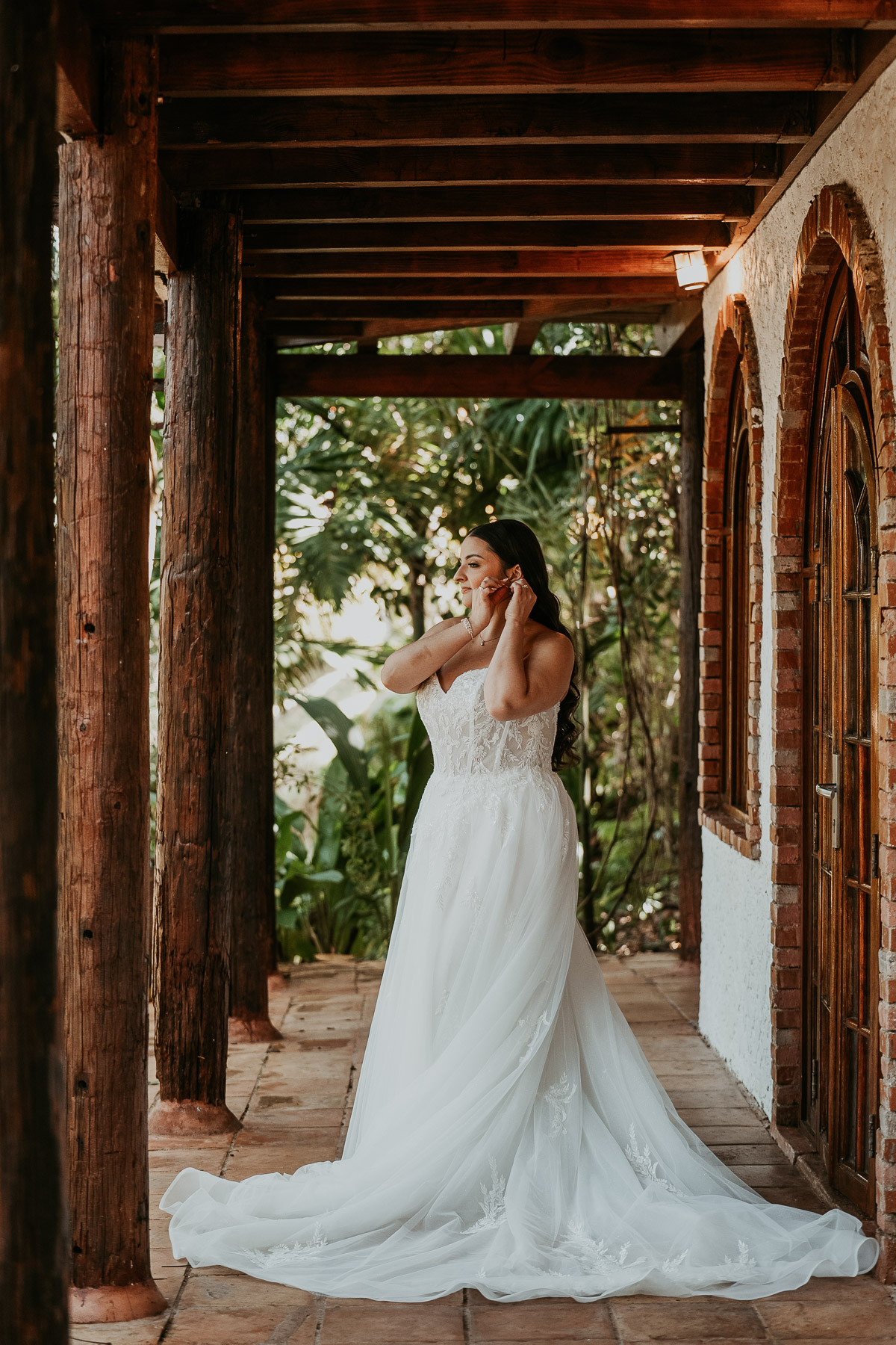 Bride adjusting her wedding jewelry while getting ready