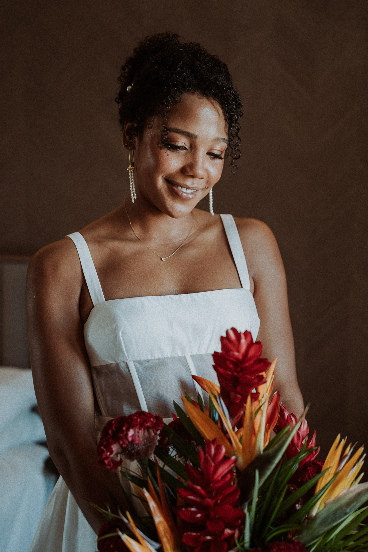 Bride holding her bouquet featuring vibrant tropical florals.