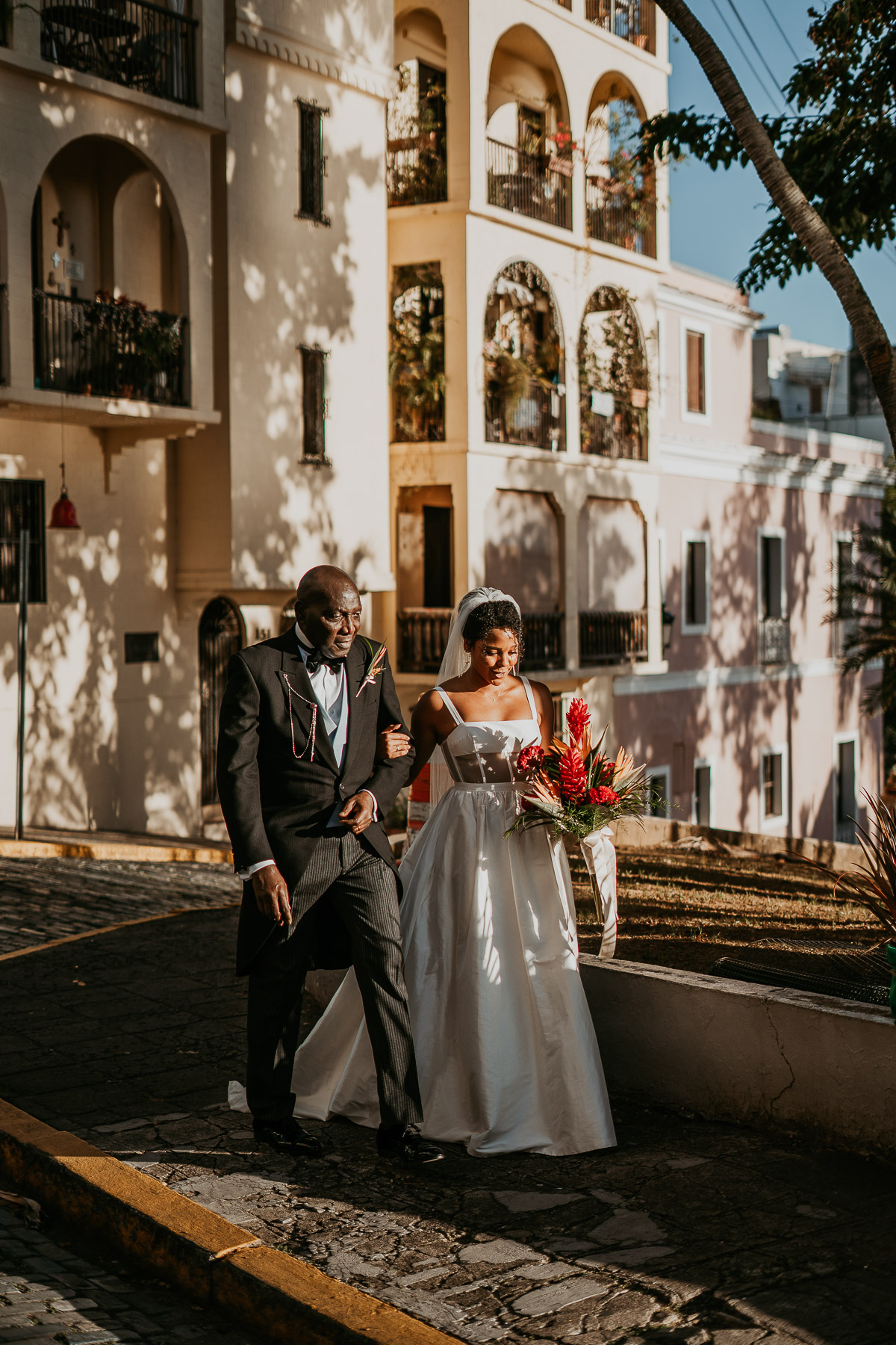 Bride walking down the aisle at La Rogativa accompanied by a parent.