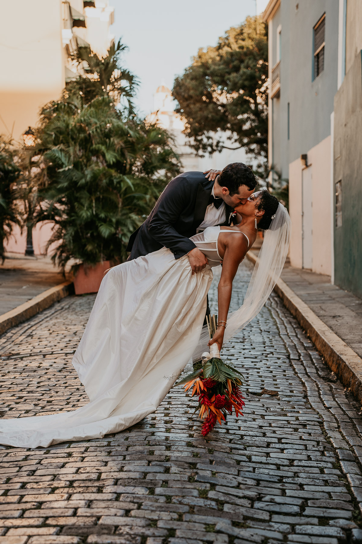 Bride and groom stealing a kiss in a cobblestone street of Old San Juan.