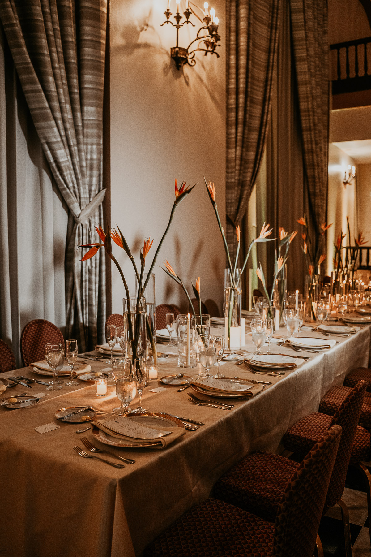 Floral centerpieces with candles glowing on reception tables.