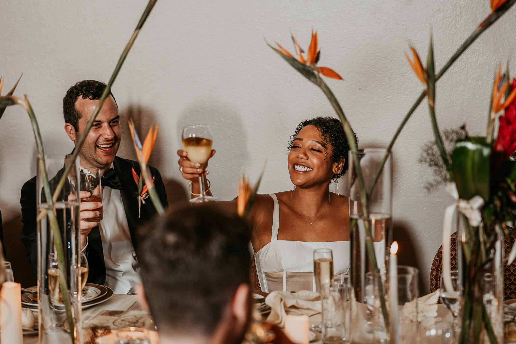 Bride and groom laughing together during a heartfelt toast.